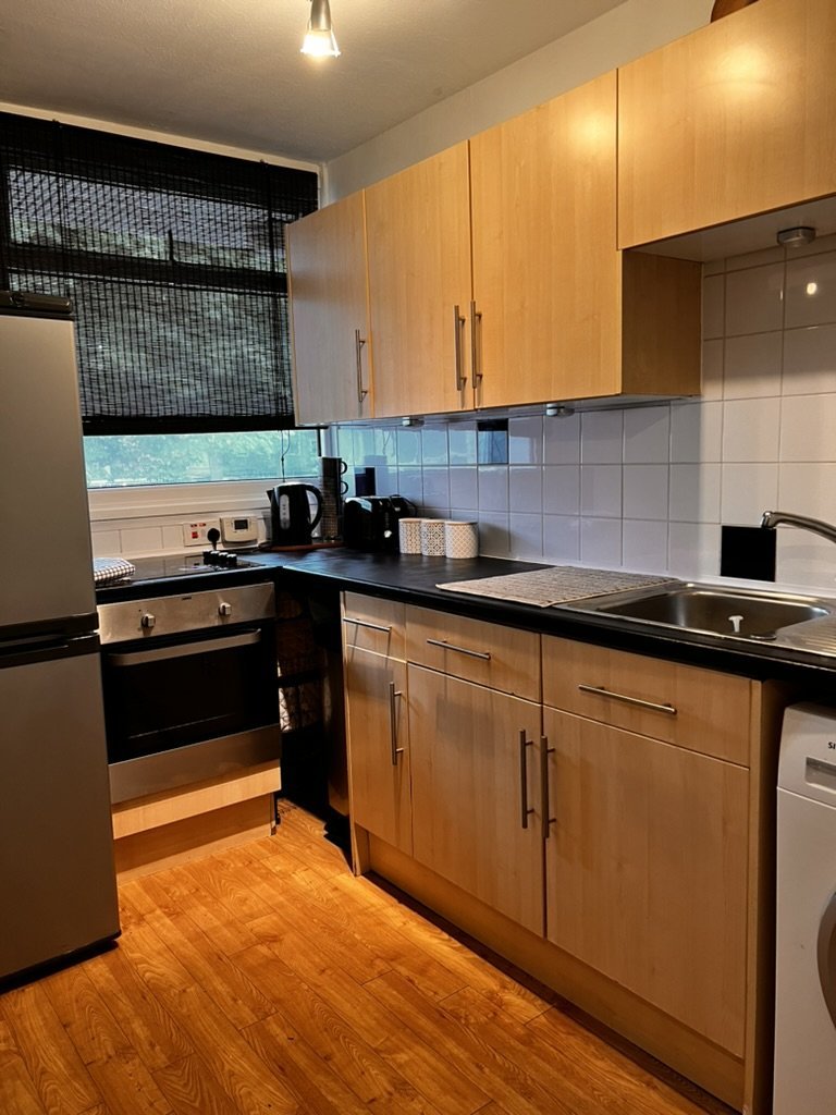 After home staging: London kitchen with wall-mounted boiler, net curtain and wood cabinetry