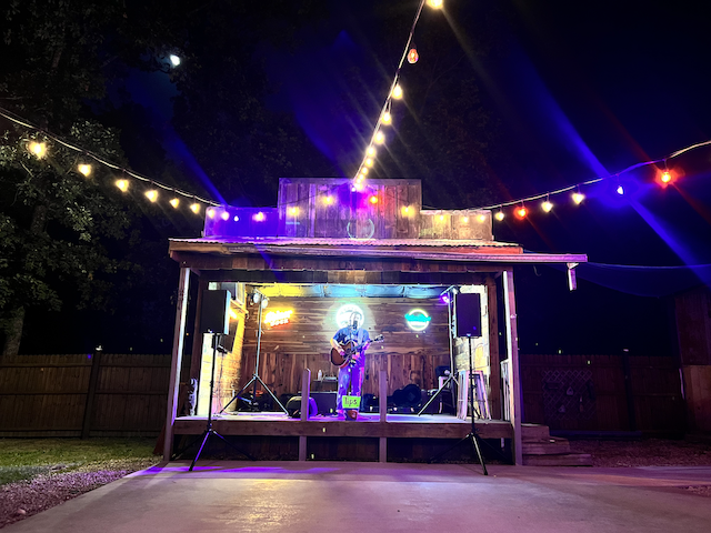 Outdoor stage with solo guitarist at Lakeside Bar and Grill