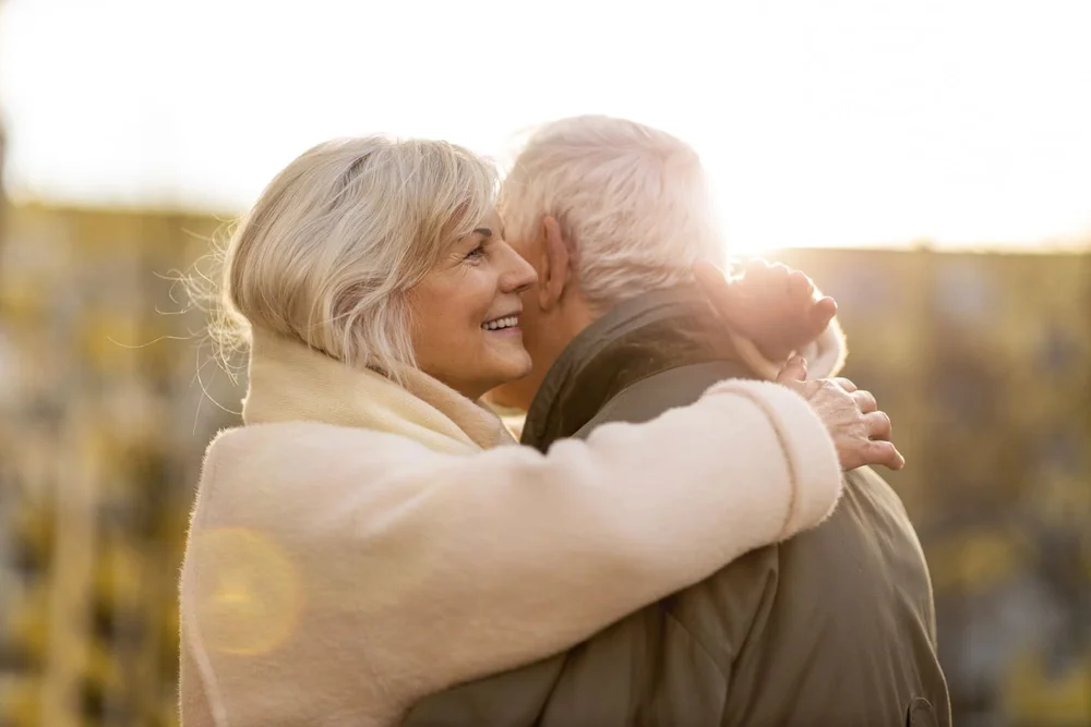 Un couple de seniors qui s'enlace, au soleil