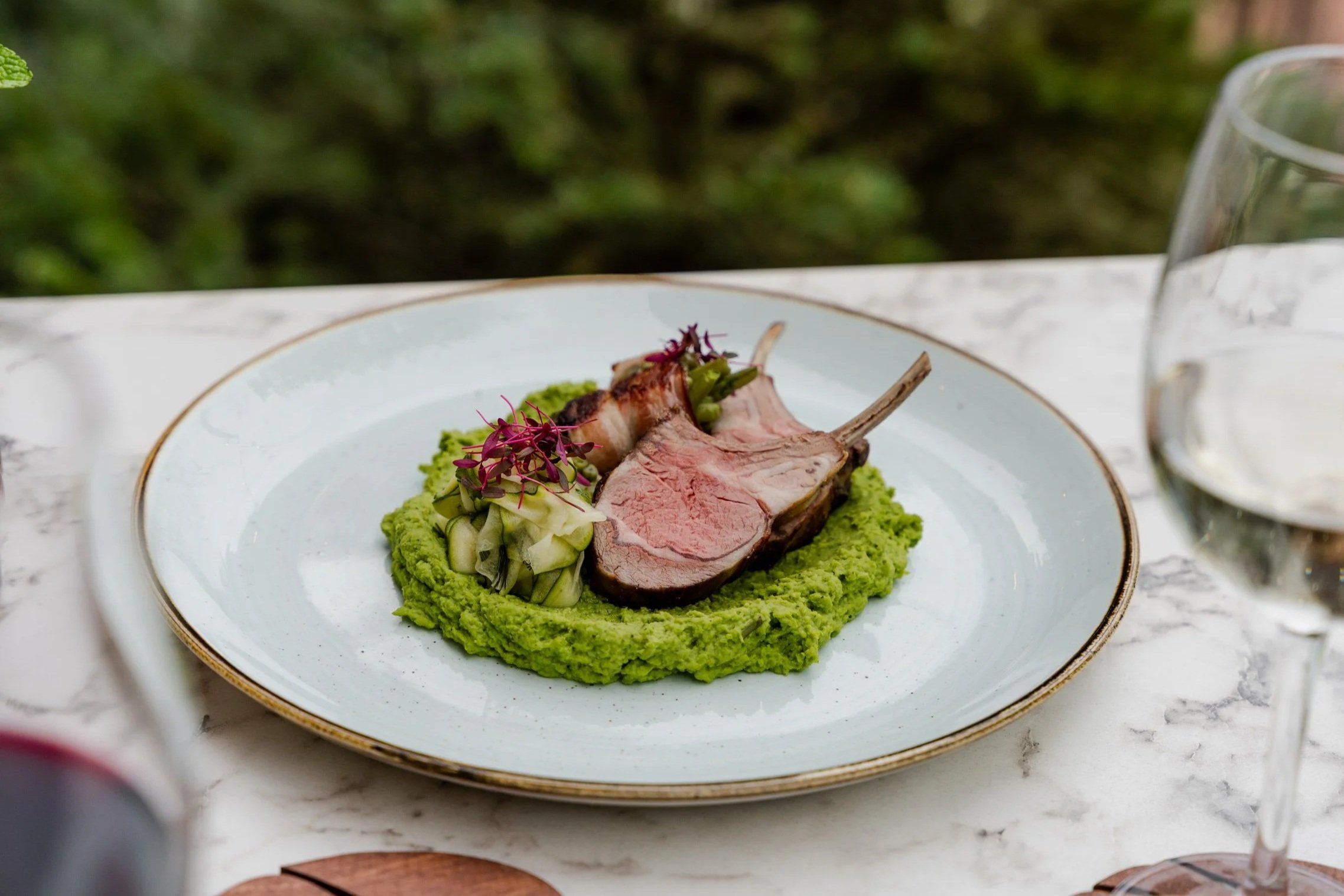 Succulent lamb chops served with bacon green beans, minty green pea purée, and marinated zucchini.