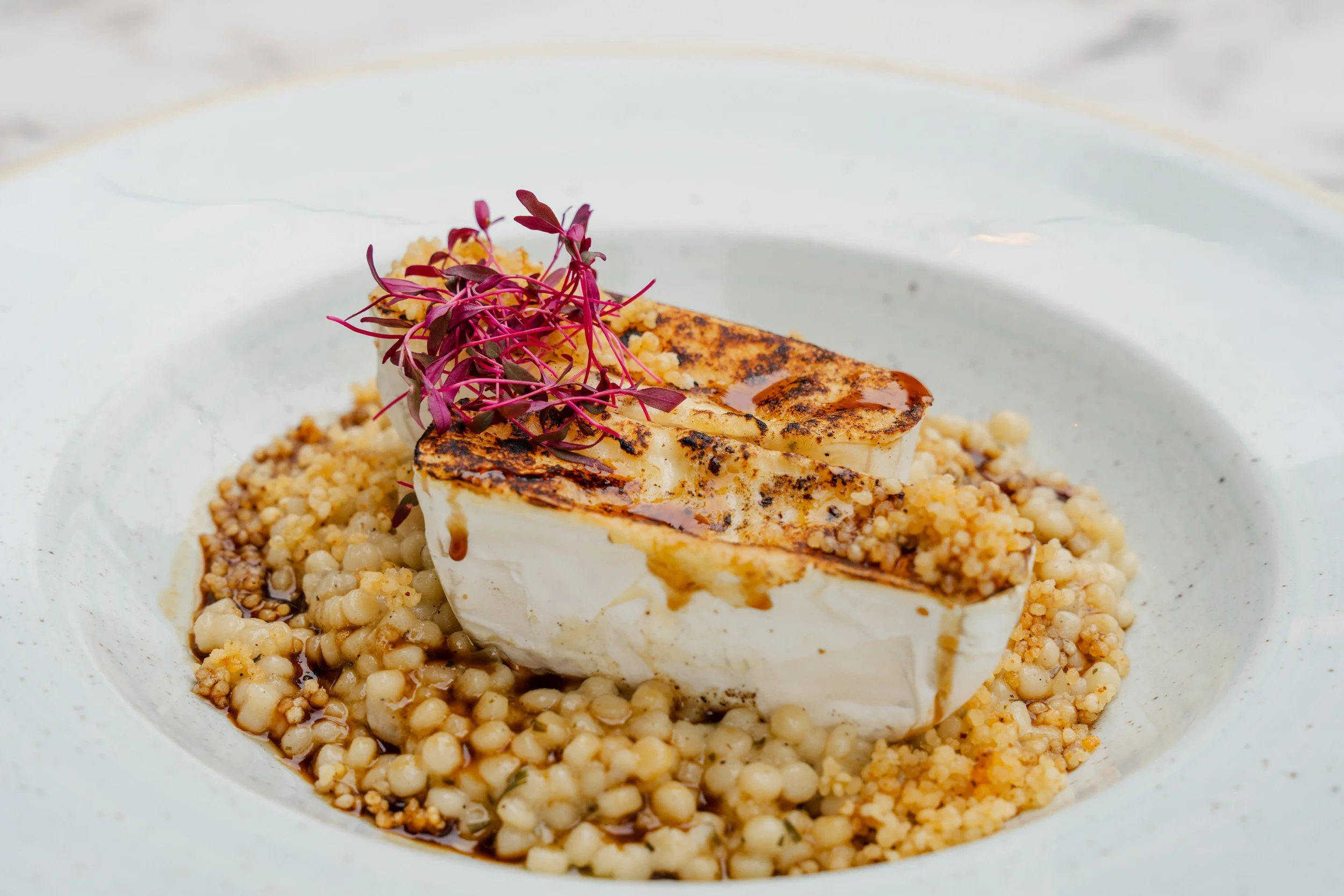 oasted camembert served with tarragon egg barley risotto, cherry jus, and millet crunch.