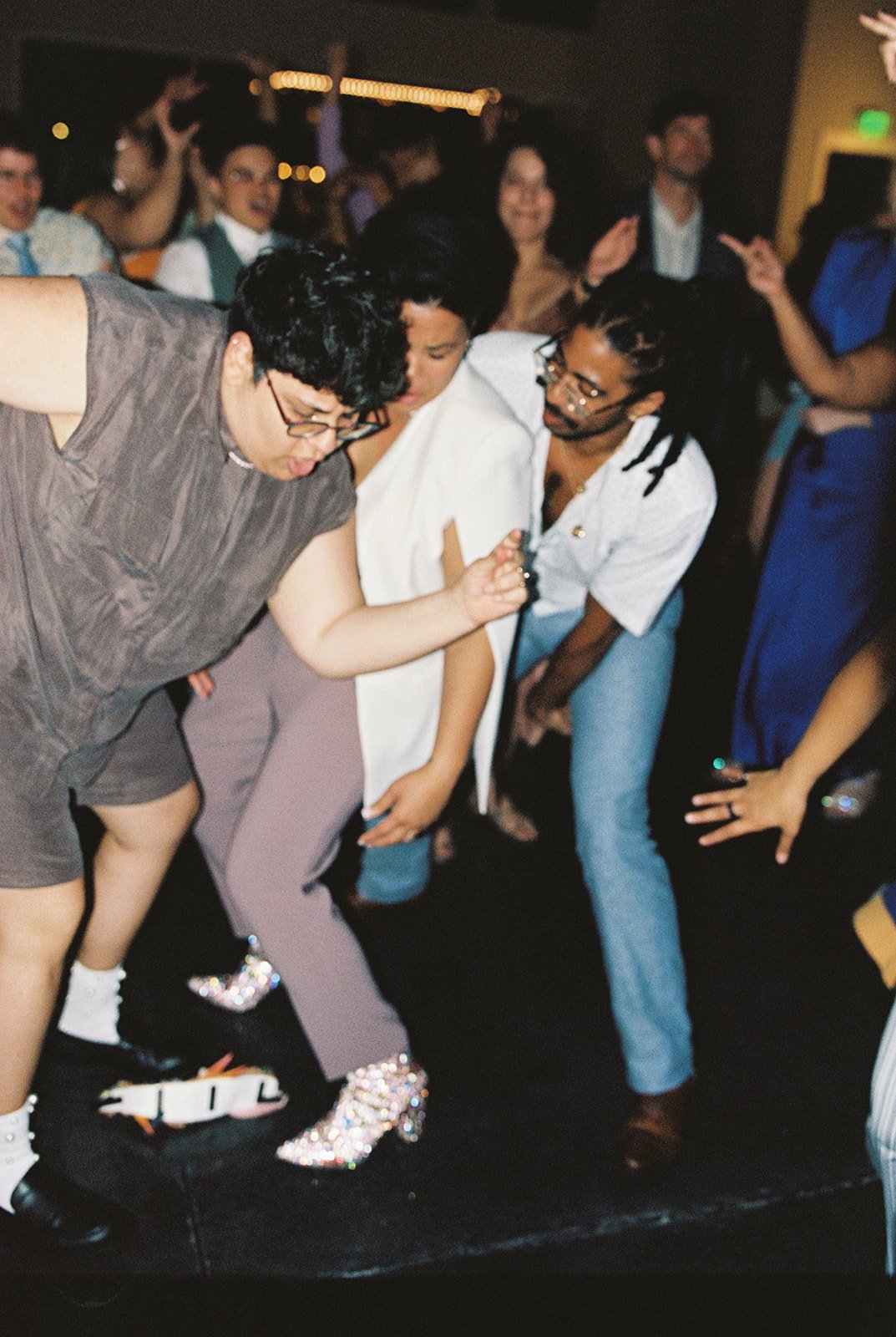 Wedding guests dressed in colorful outfits dancing on the dance floor at a wedding on the Oregon Coast