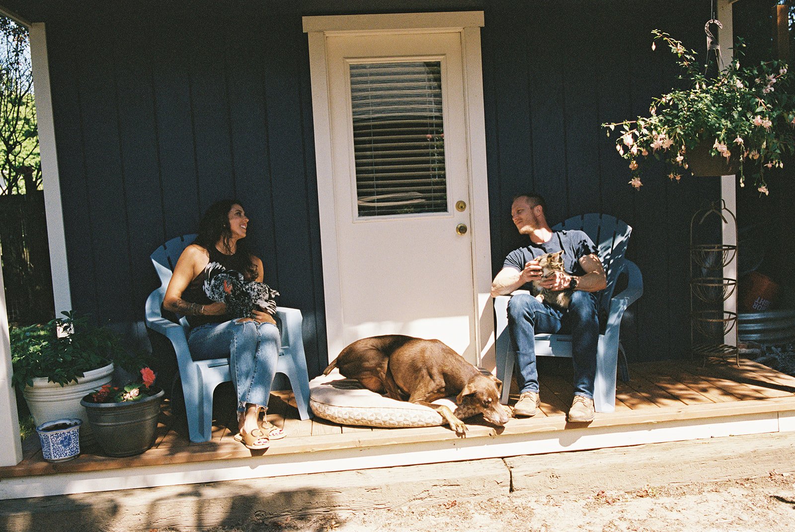 A couple sitting on the porch with their pets while taking at home family photos in Oregon