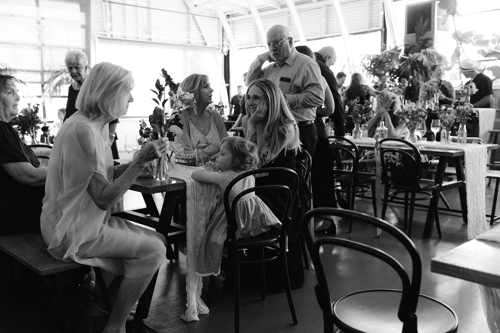 wedding guests sitting at a table visiting and having dinner at a wedding reception in Portland, Oregon.