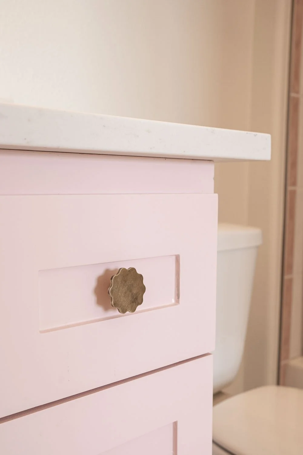 Bathroom design with light pink cabinets.