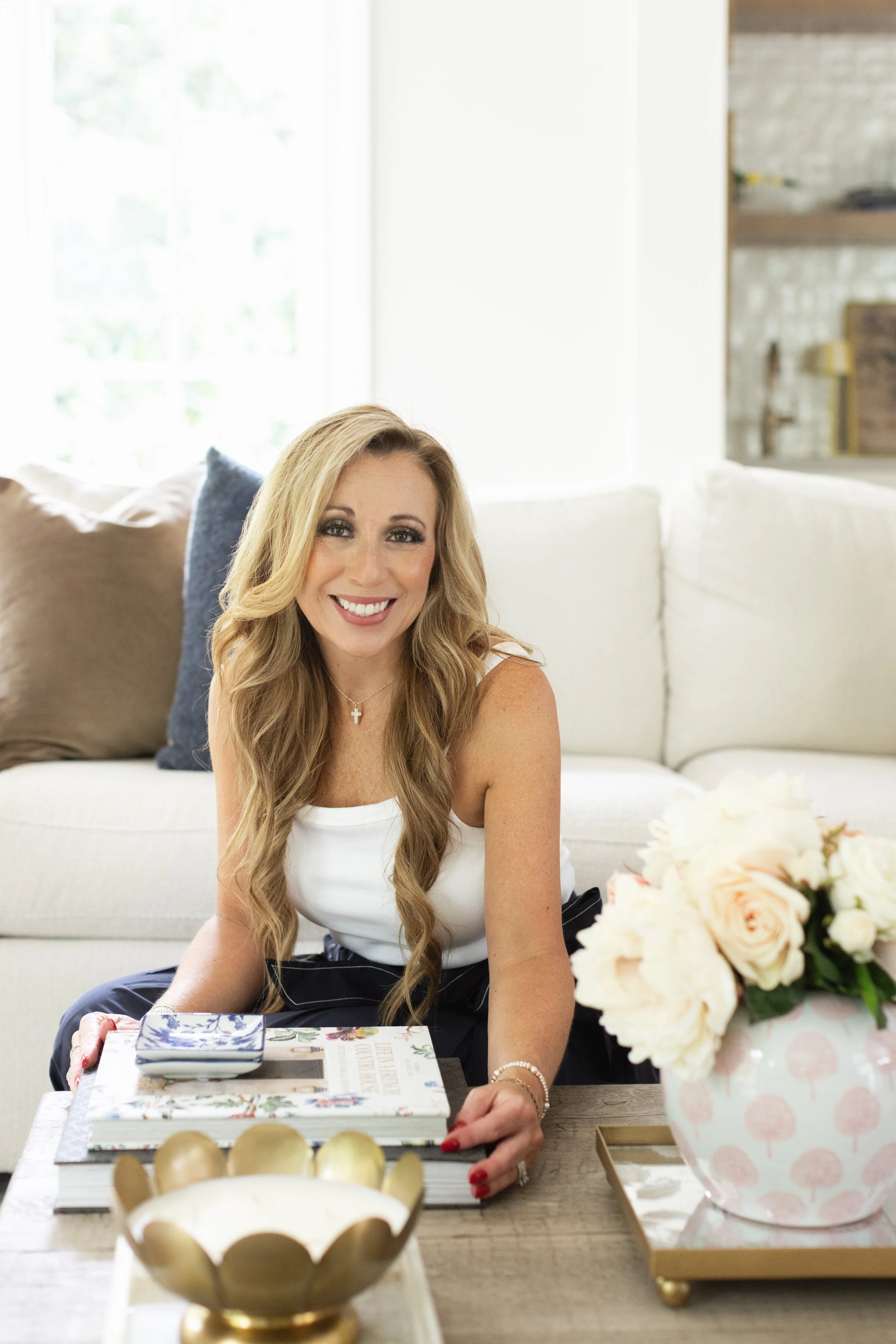 Xela Andrews, owner of Xela Andrews Interiors, smiling at the camera while posing in a clean, modern living room.