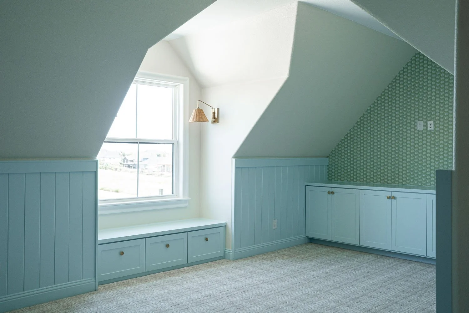  Farmhouse interior design bedroom with sage green beadboard walls, warm paint tones, built-in window seat, and vaulted ceiling showcasing timeless interior design details. 