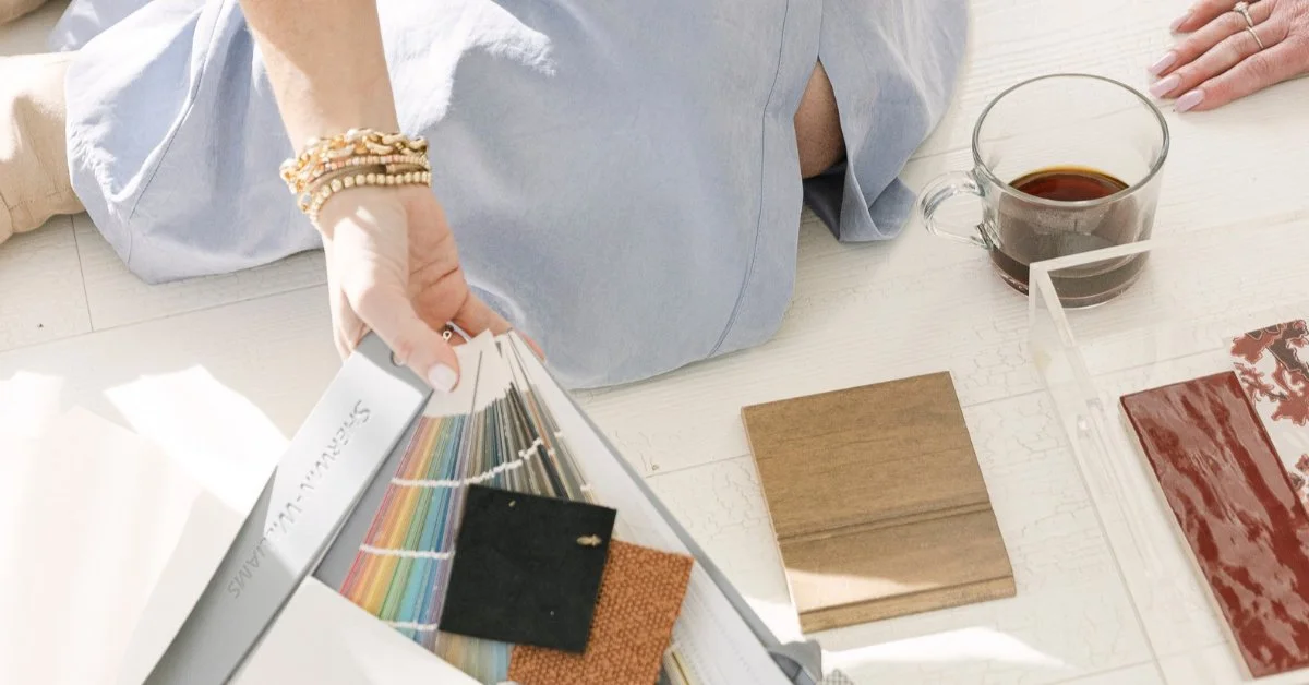 Sherwin-Williams fan deck, fabric swatches, wood sample, and tile laid out to explain what an interior designer does