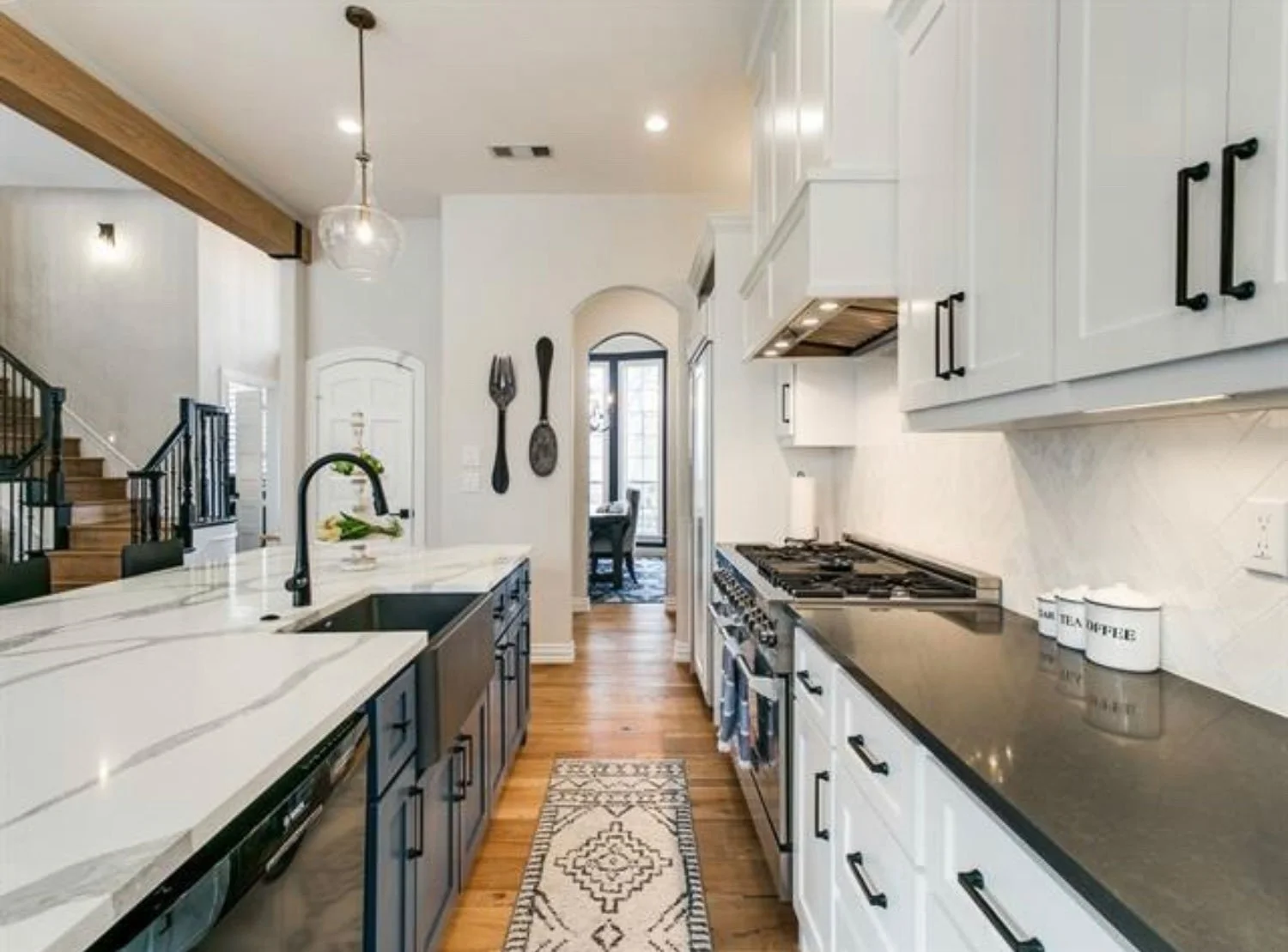 Farmhouse kitchen with dark countertops, white shaker cabinets, and timeless interior design details.