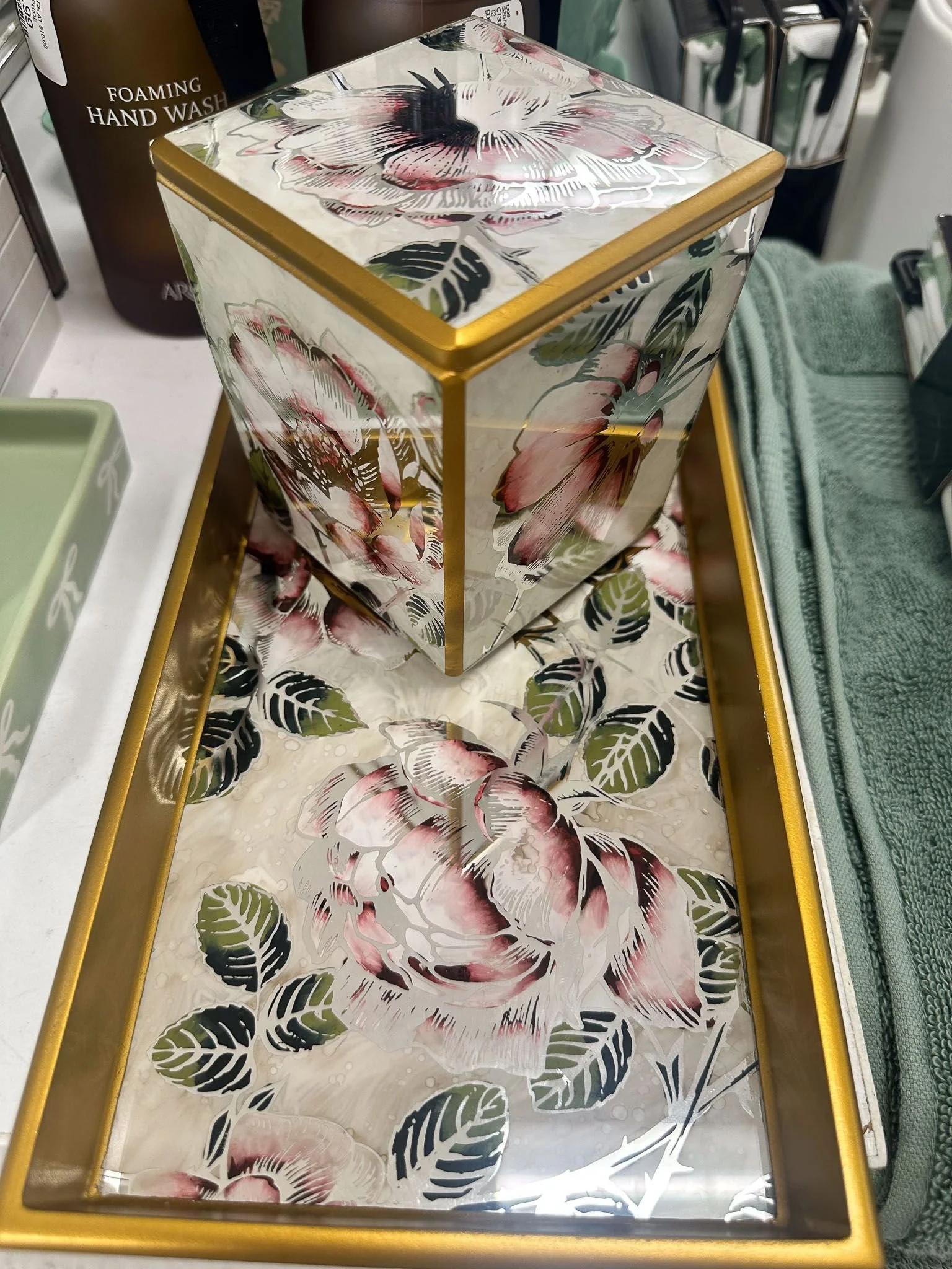 Bathroom accessories in botanical print in gold showing artistic college dorm room decor ideas for bathroom decorating.