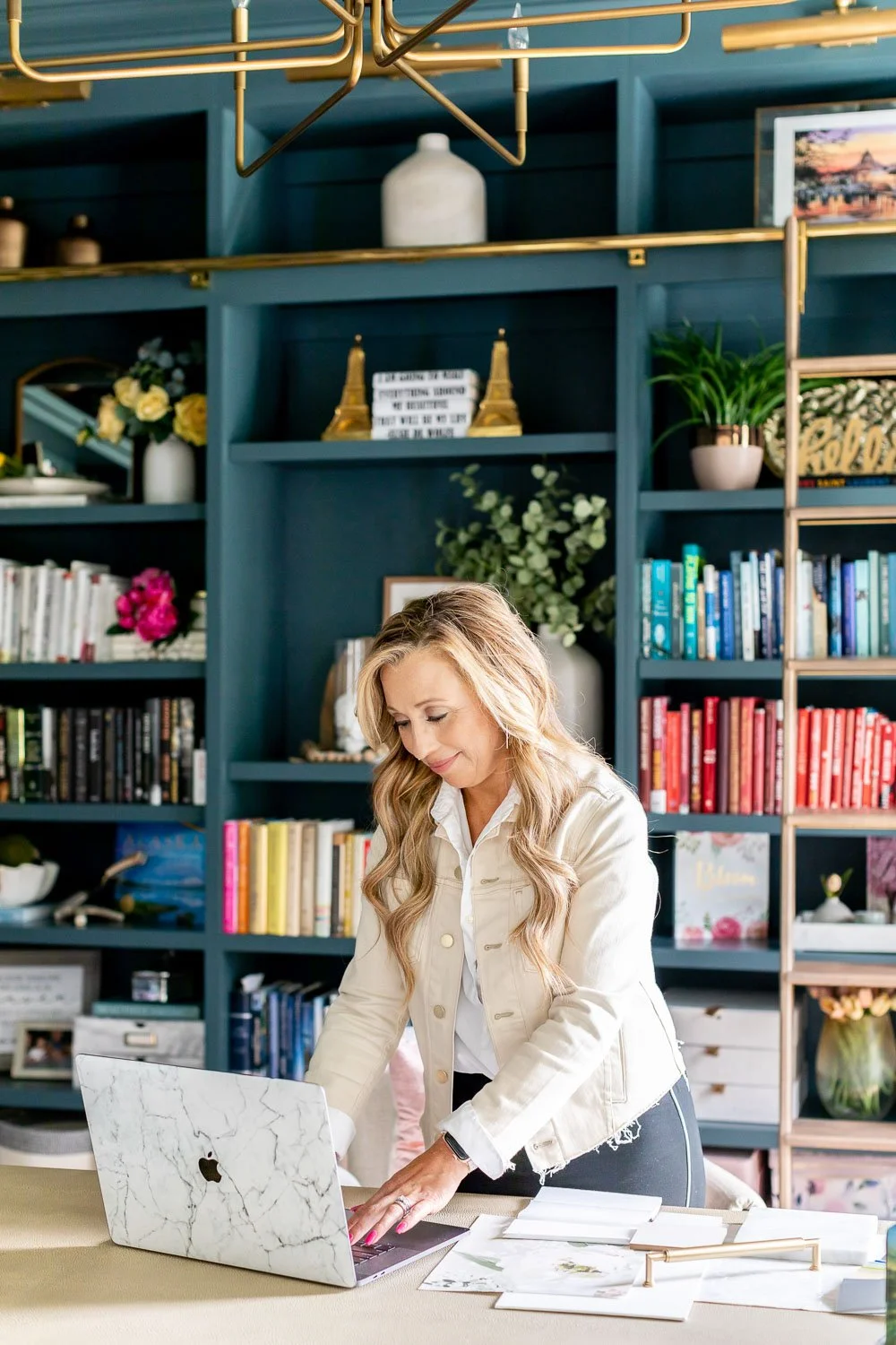 Interior designer sitting at a bright desk workspace with tips on how to find an interior designer for your home.