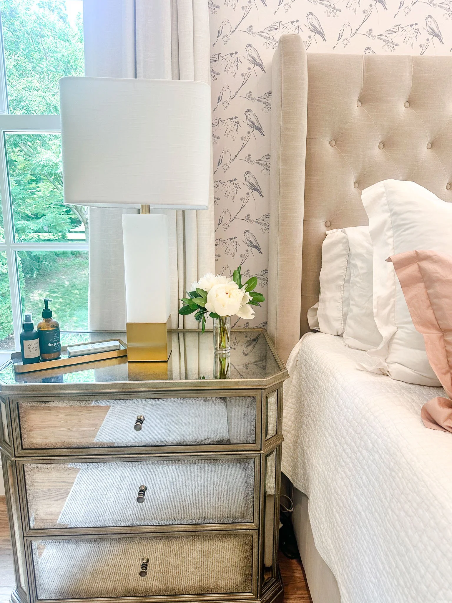 Functional design bedroom in colonial style home with mirrored nightstand and timeless decor.