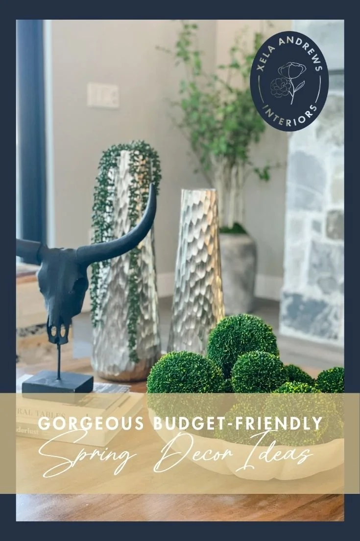Budget-friendly spring decor ideas featuring black decorative accents, coffee table books, and moss balls in a white bowl.