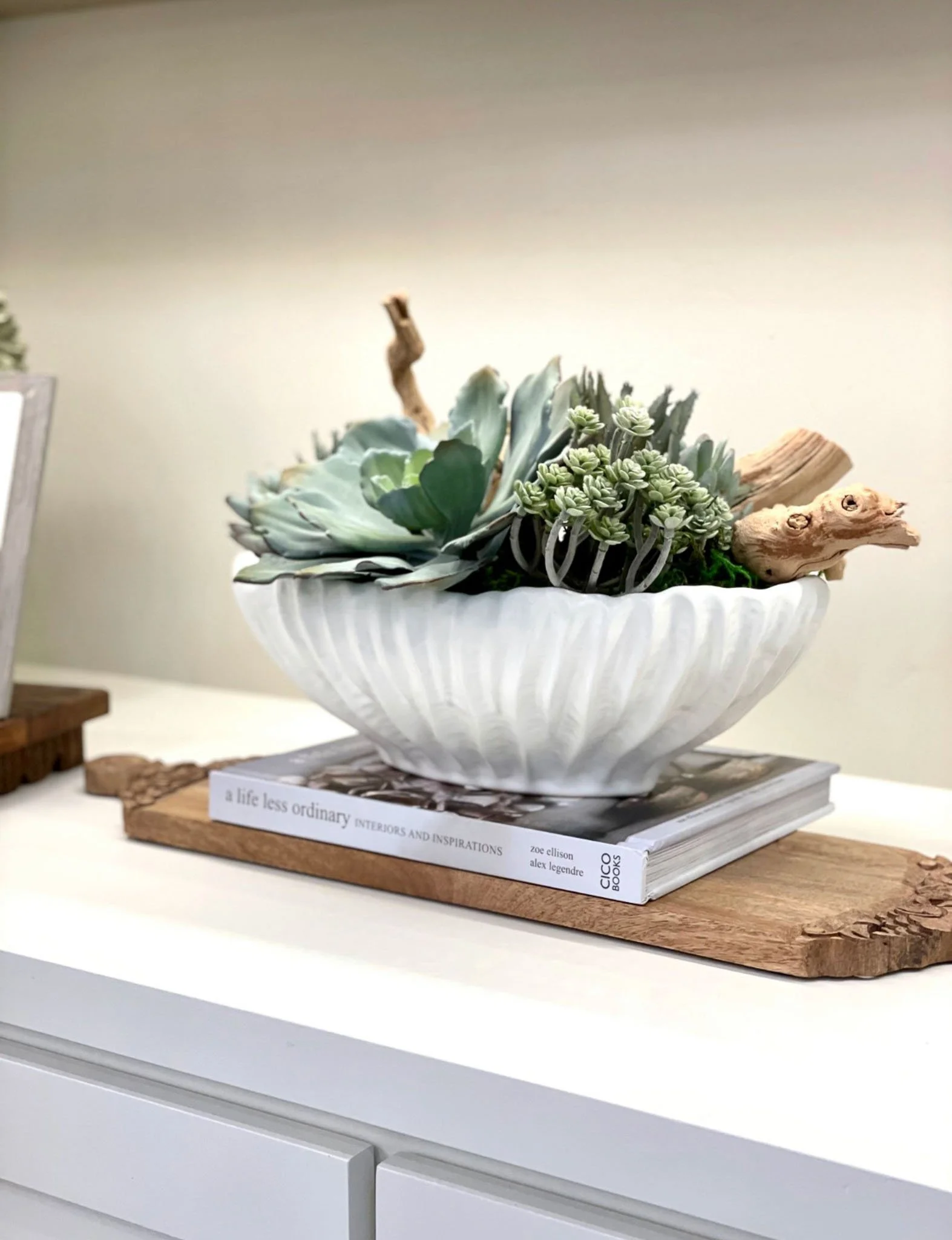 Stylish entryway decor featuring a white shell bowl with succulents on a wooden tray, perfect for summer home styling.