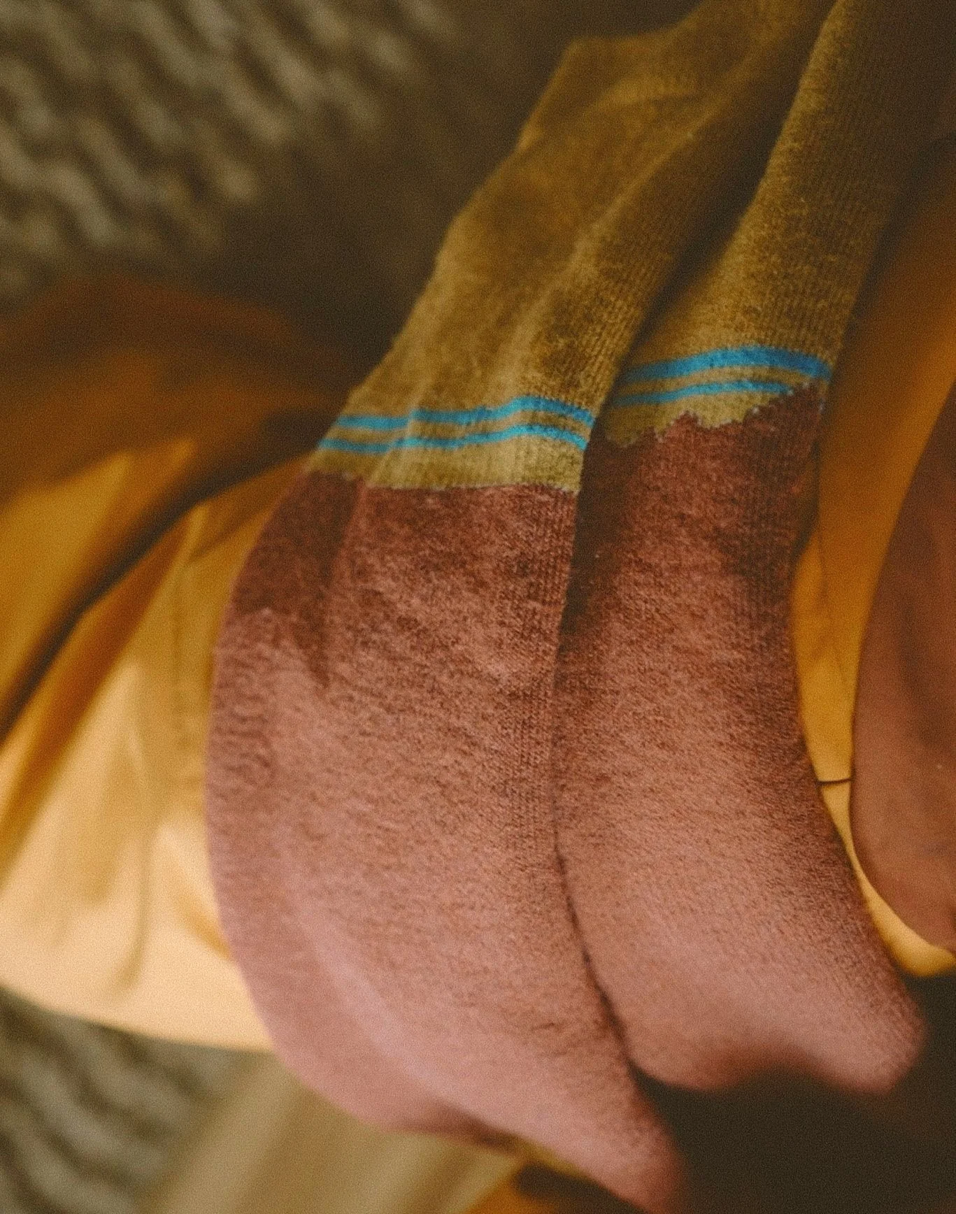 Close-up of a multicolored striped fabric, with shades of brown, red, and blue, hanging or draped.