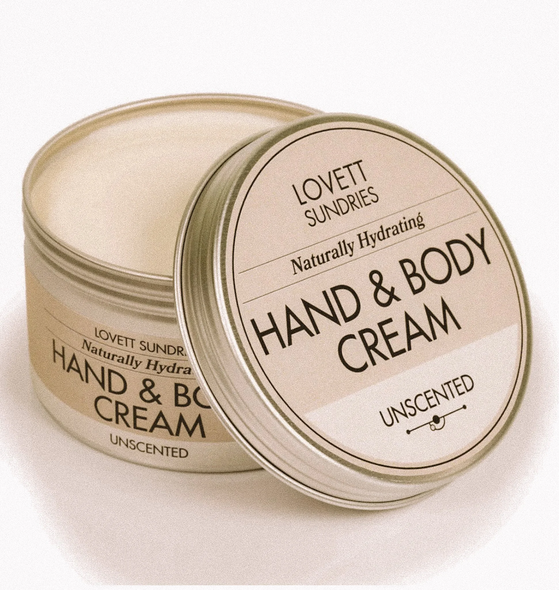 An open tin of Lovett Sundries Unscented Hand & Body Cream with a beige label.