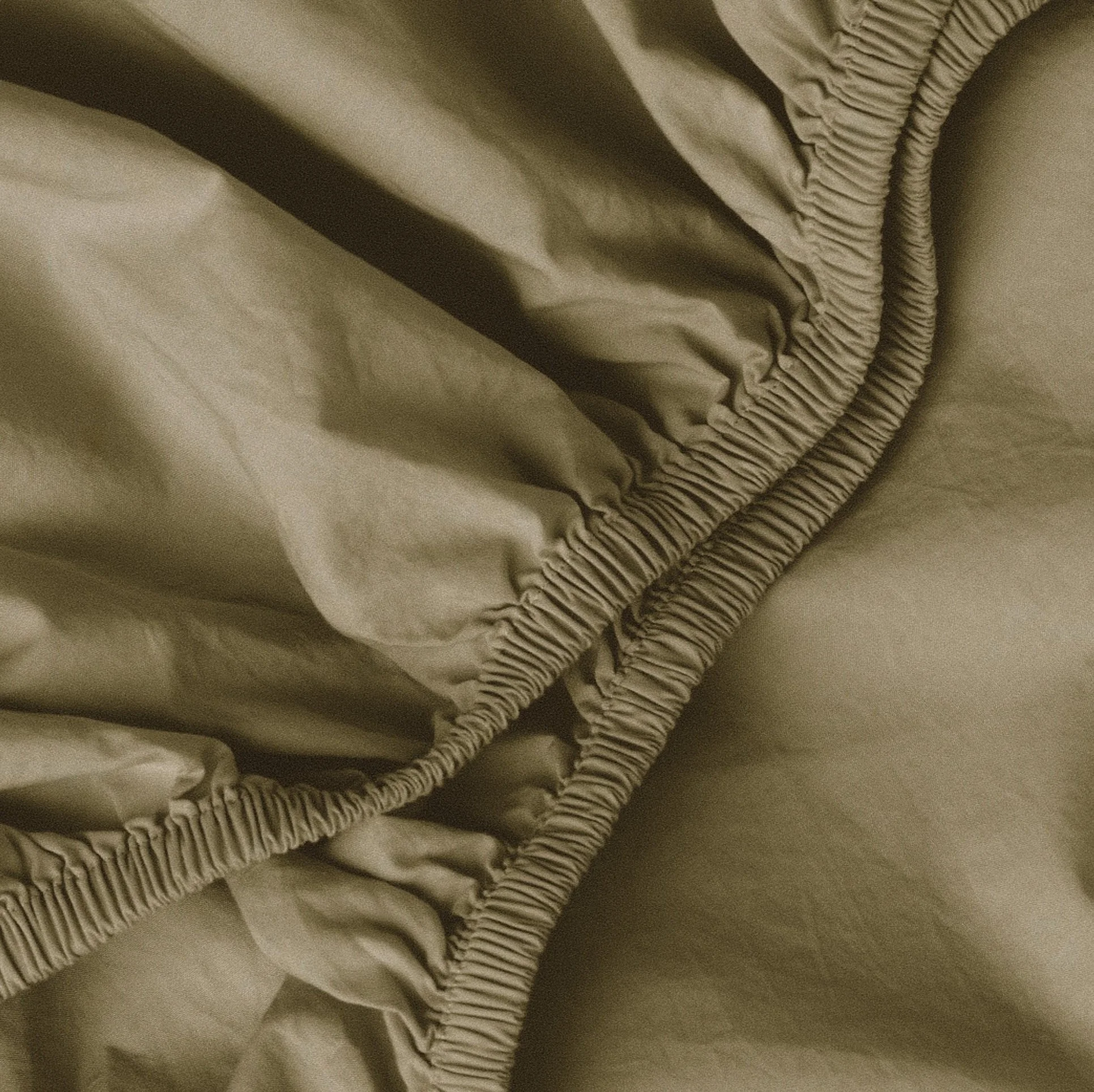 Close-up of beige fabric with gathered elastic seams.