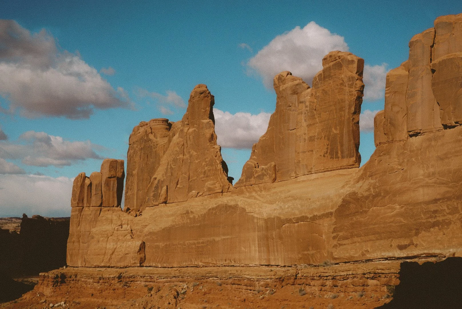 Rock formations in a desert landscape with a partly cloudy sky.