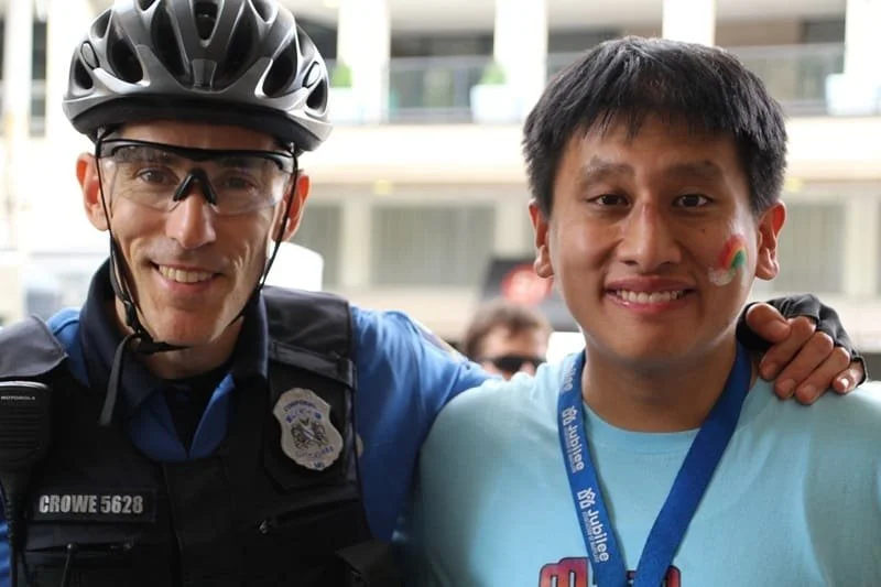 Officer wearing helmet and young man both smiling
