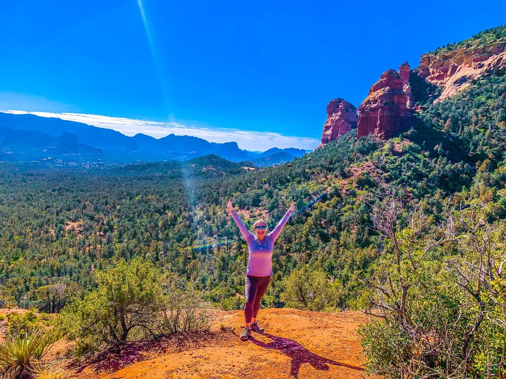 Katie Sutton with her hand raised to the sky in the Arizona desert