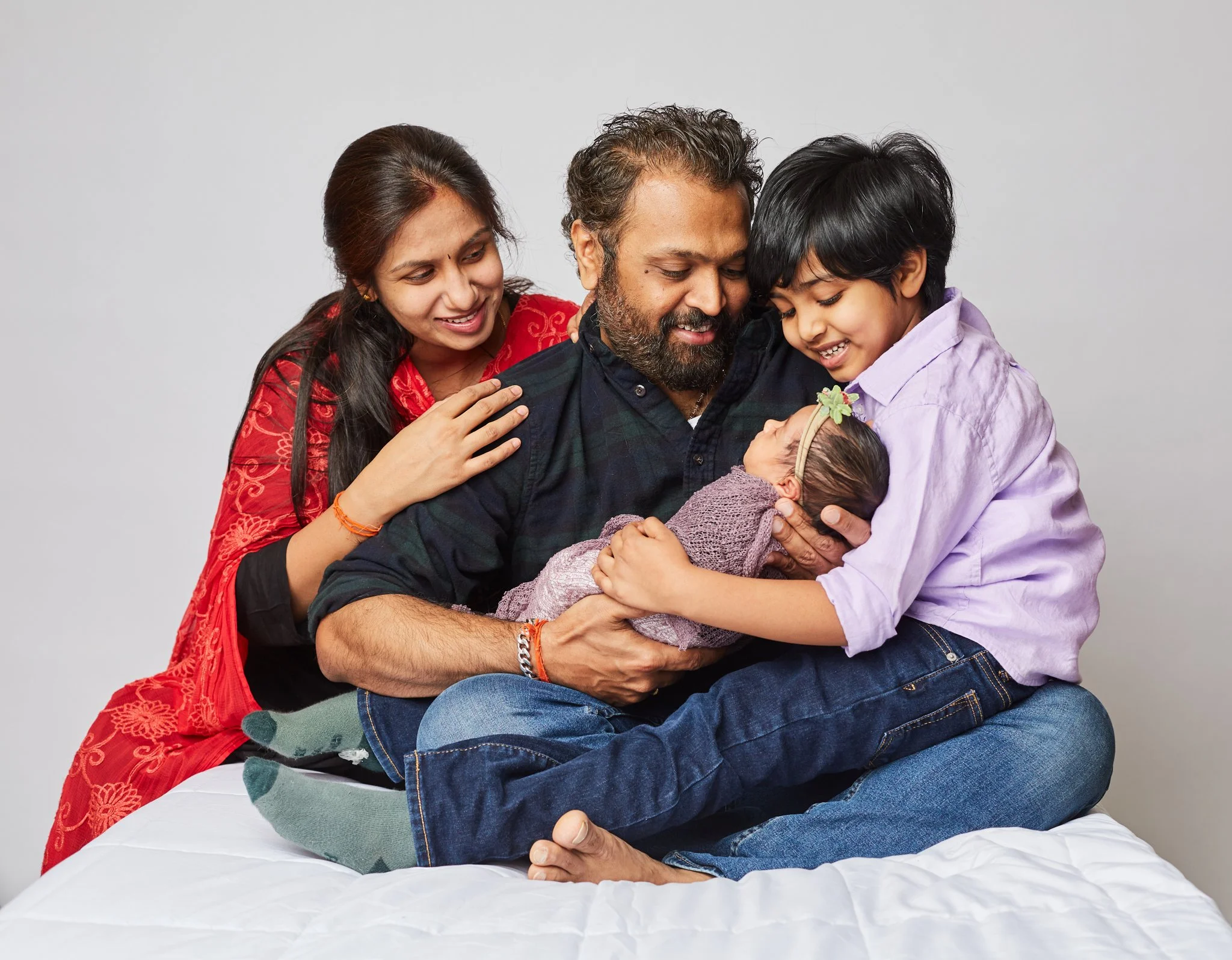 Family portrait in studio with young boy and newborn baby