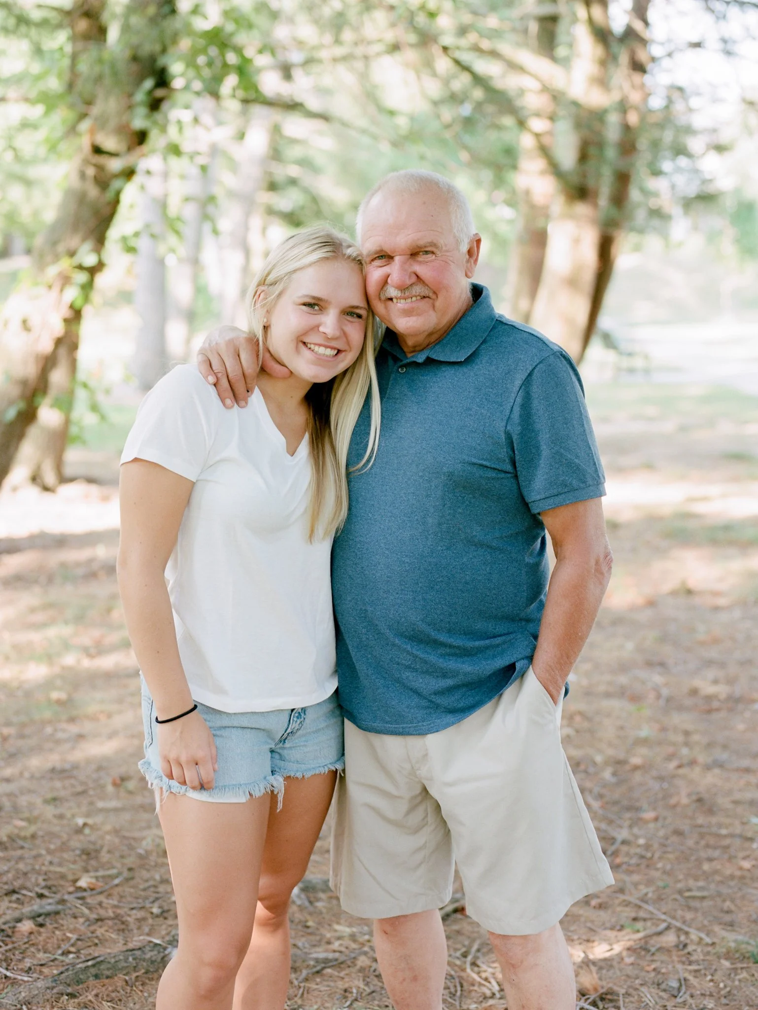 Father and daughter posing for portrait outdoors in the shade