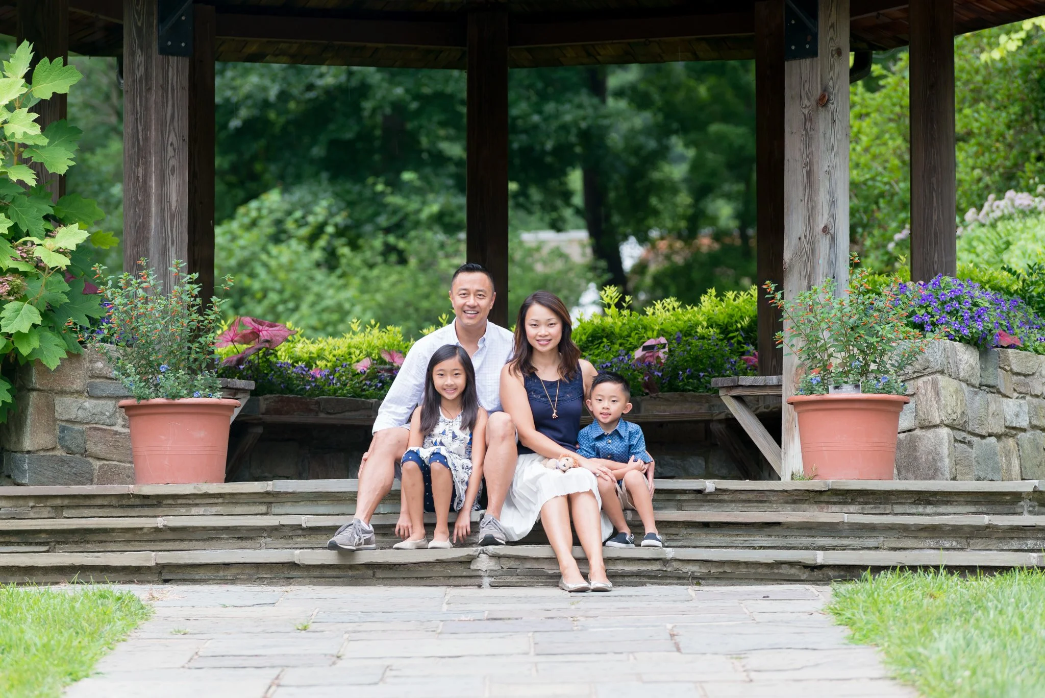 Family with son and daughter sitting on steps outdoors