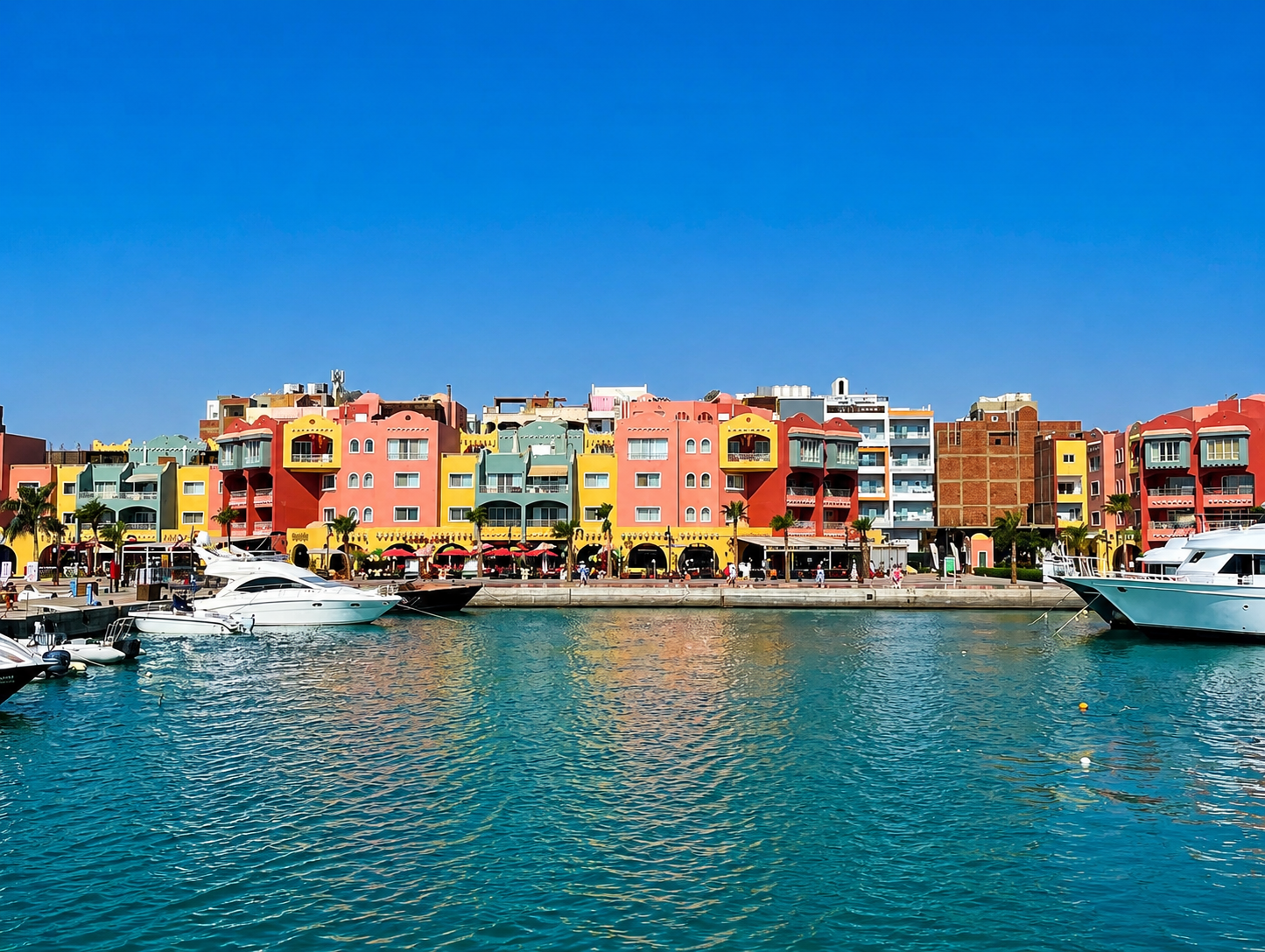 Paseo marítimo de la Marina de Hurghada, rodeado de embarcaciones, restaurantes y zonas de ocio junto al Mar Rojo.