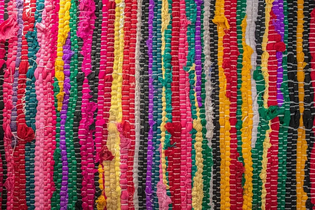 A closeup of a woven rug in rainbow colors.