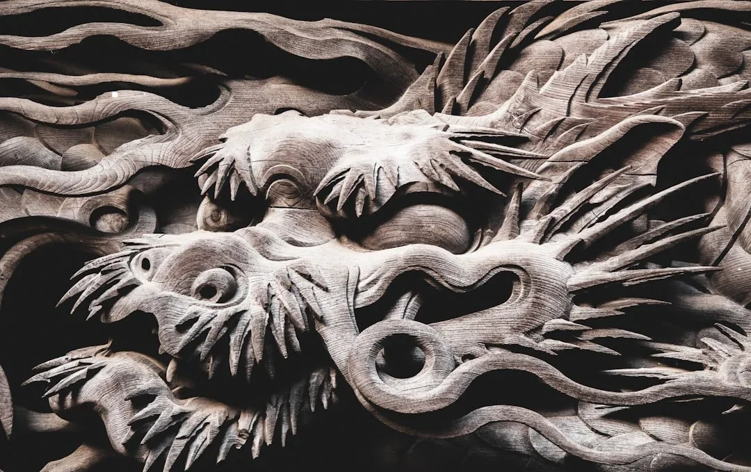 Detailed wooden carving of two dragons intertwined with flowing mane details.