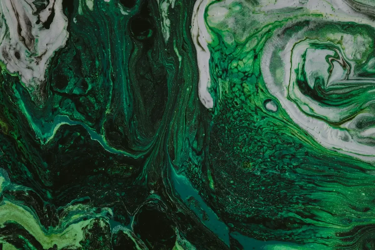 Abstract green and black marbled swirling pattern, resembling fluid art or swirling paint.