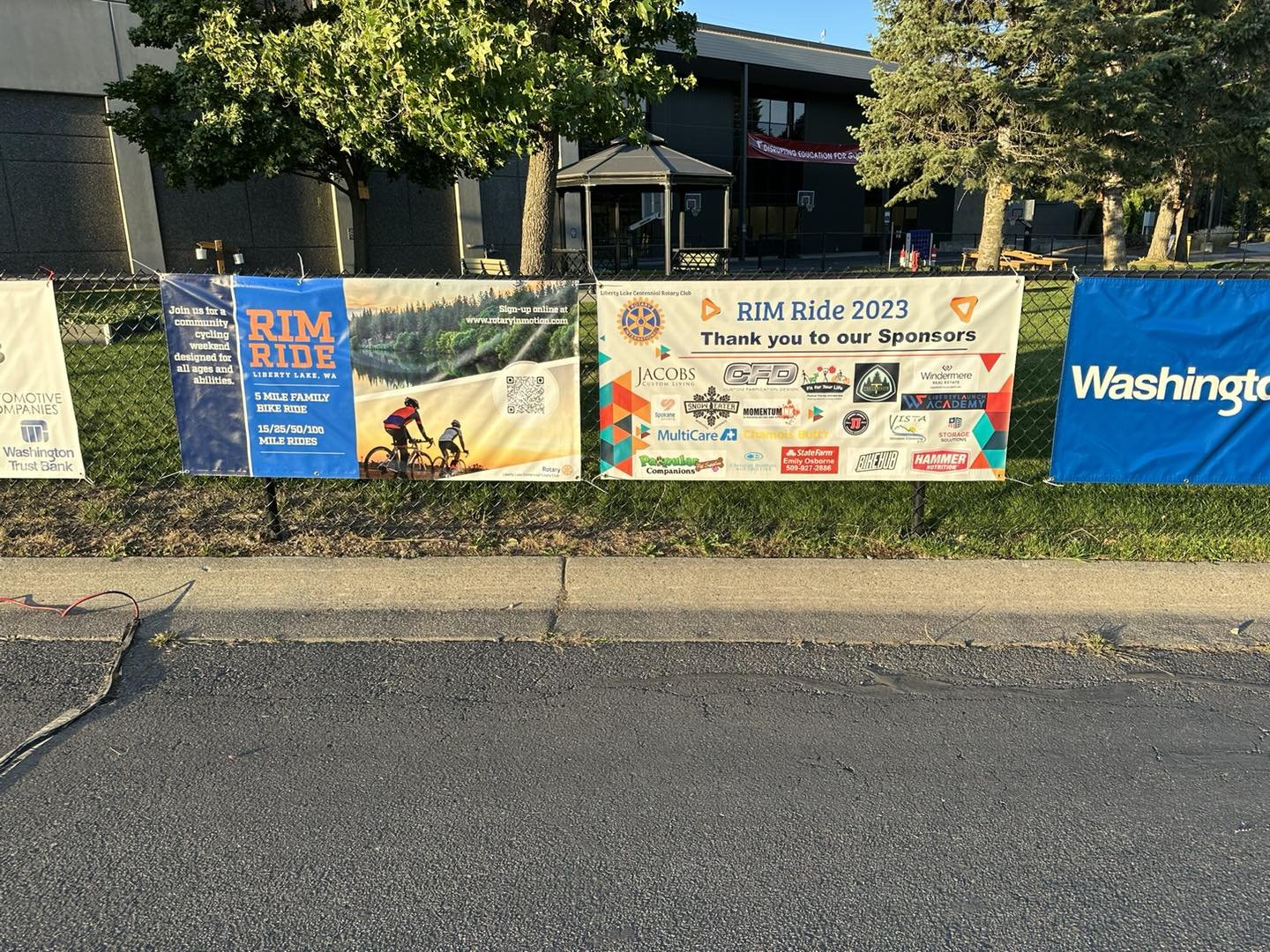 Outdoor event banners for RIM Ride 2023 in Liberty Lake, Washington, sponsored by various local businesses and organizations, featuring images of cycling and logos of sponsors.