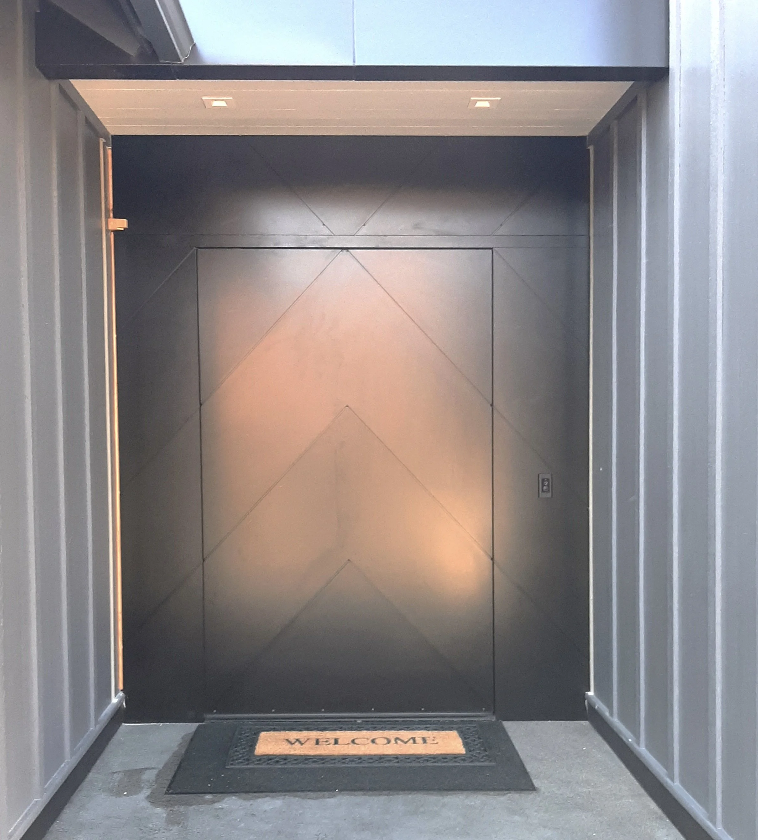 Elevator door with a welcome mat in front.