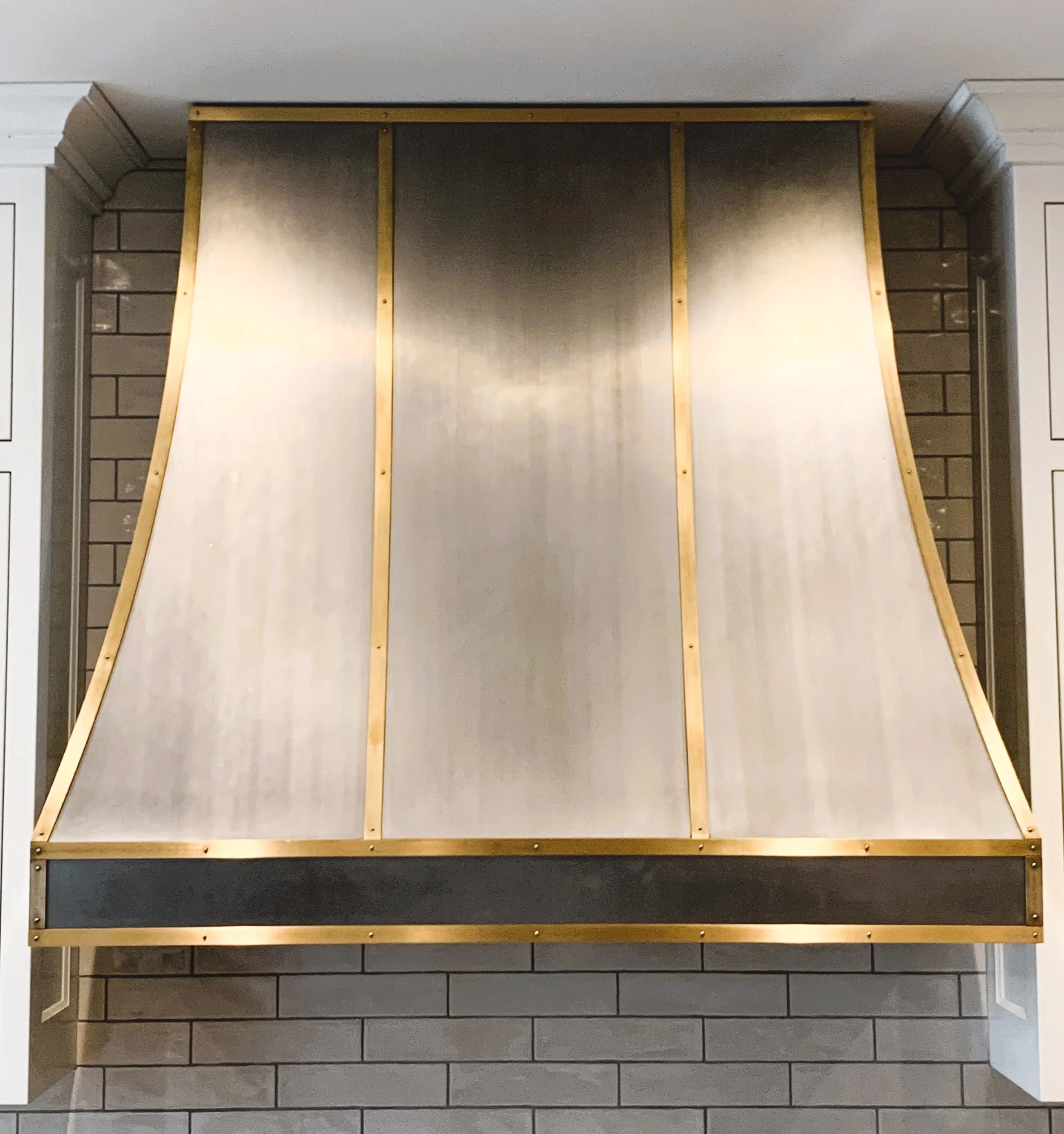 A large metal slide with a wooden frame, set between two brick walls.