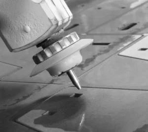 Close-up of a laser cutting machine cutting through a sheet of metal.