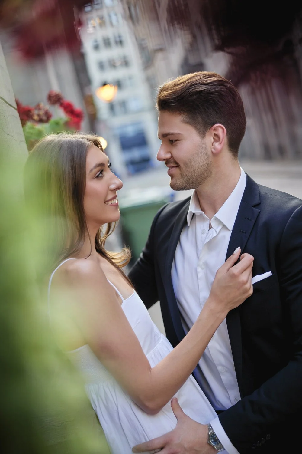 A portrait of a young man and woman holding each other.  They're dressed formally.
