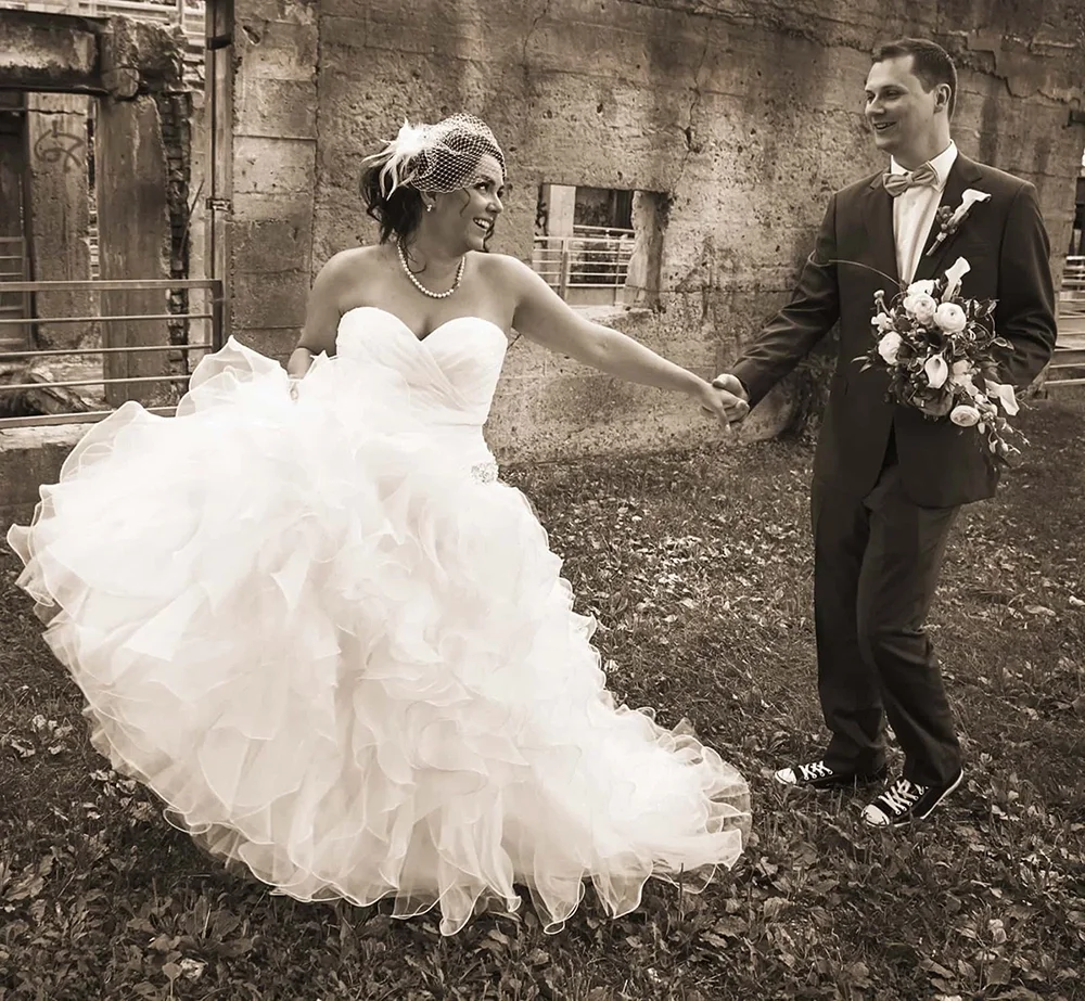 A portrait of a bride and groom walking hand in hand.