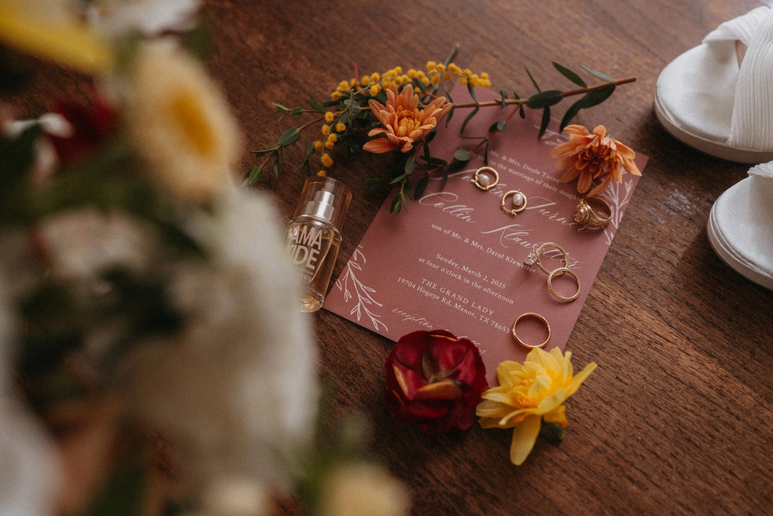 Flatlay of wedding invitations with florals, jewelry, and wedding shoes at The Grand Lady Austin wedding