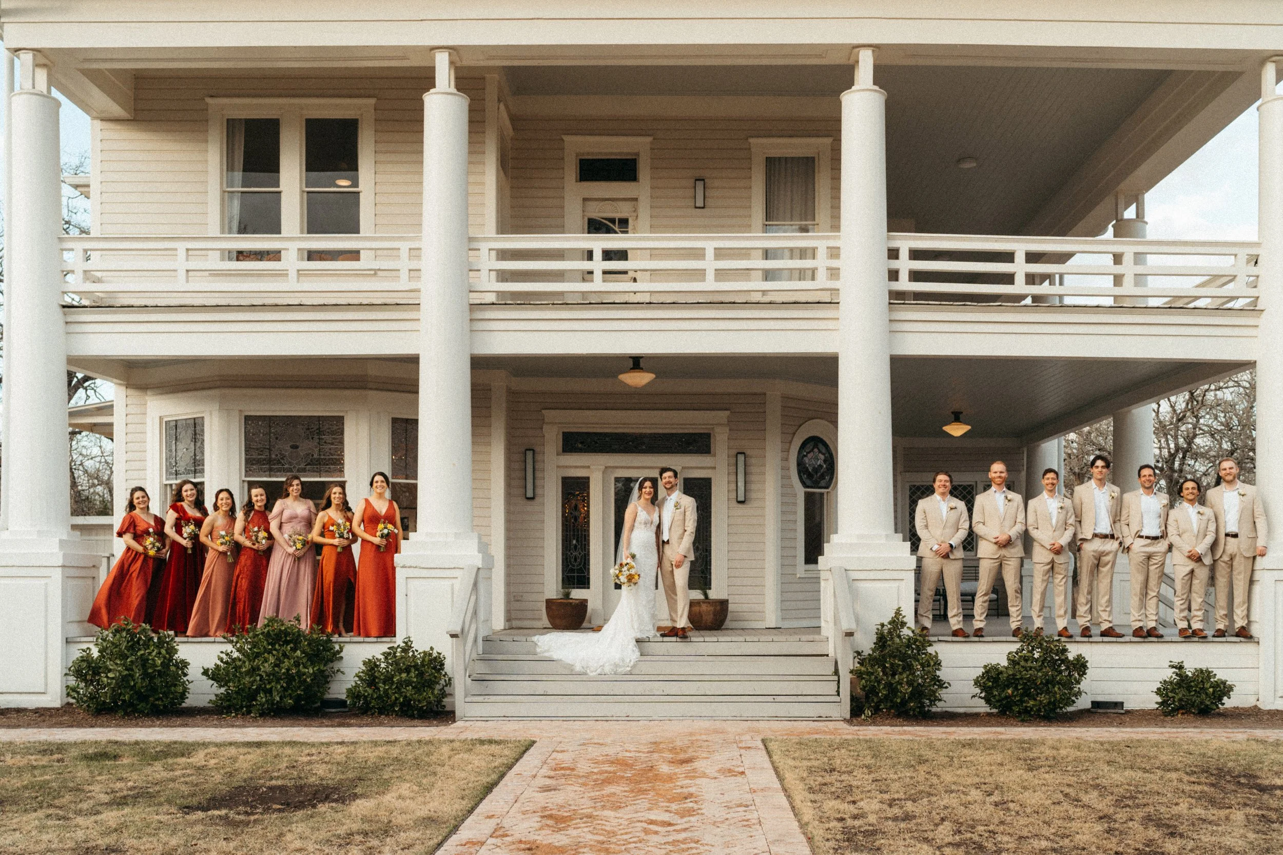 Vogue style wedding party group photo on the porch of The Grand Lady mansion