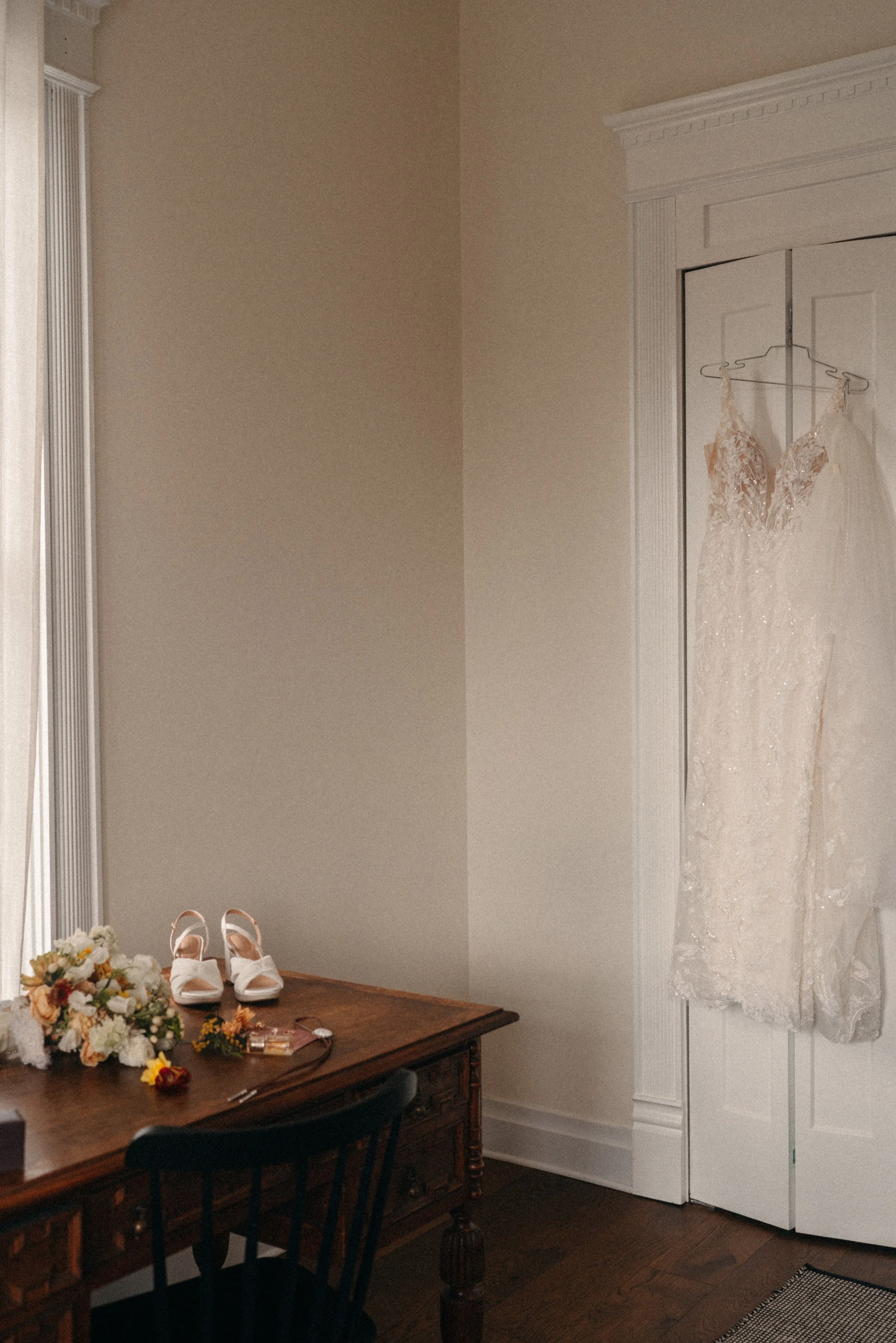Bridal gown, invitation, wedding shoes, and jewelry styled in the mansion suite at The Grand Lady