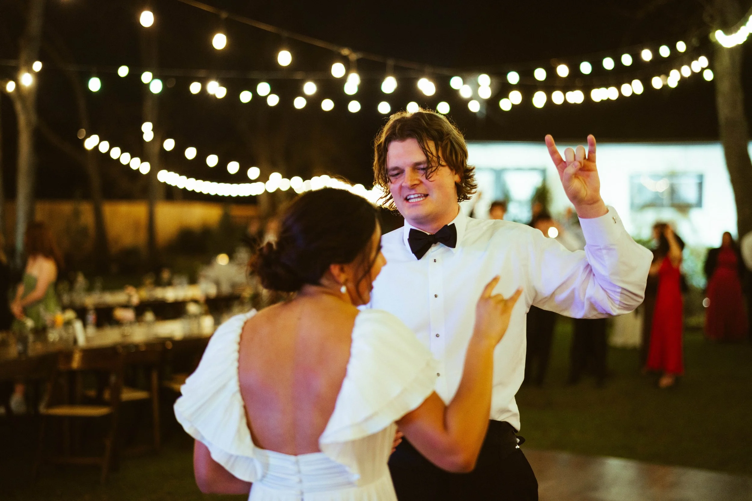 UT Austin wedding couple throwing up the longhorn sign at houston travel wedding