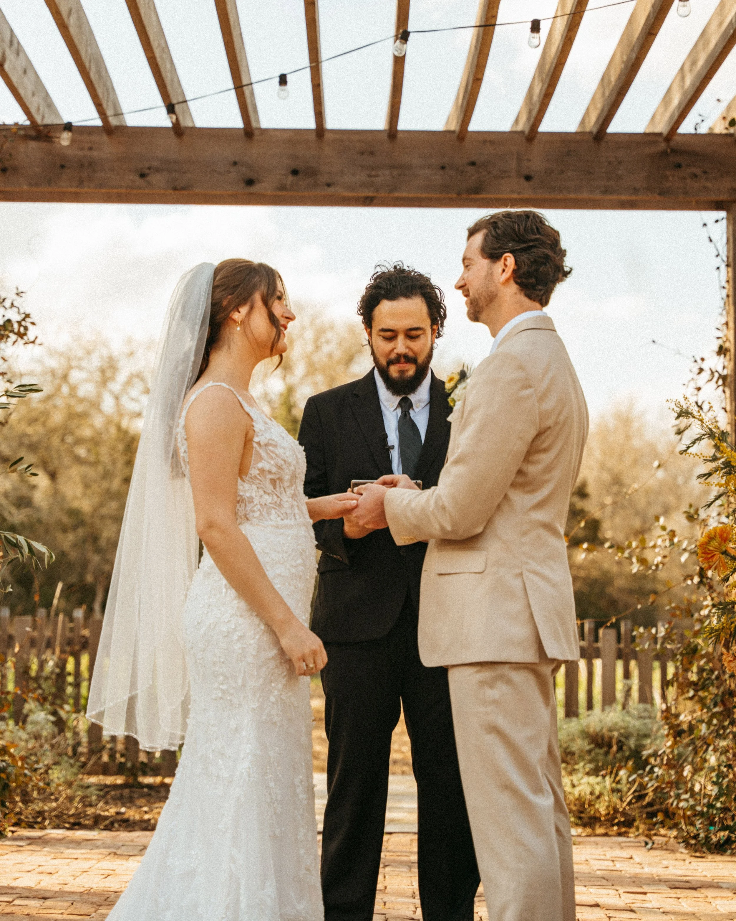 Couple holding hands during their Austin wedding ceremony at The Grand Lady pergola