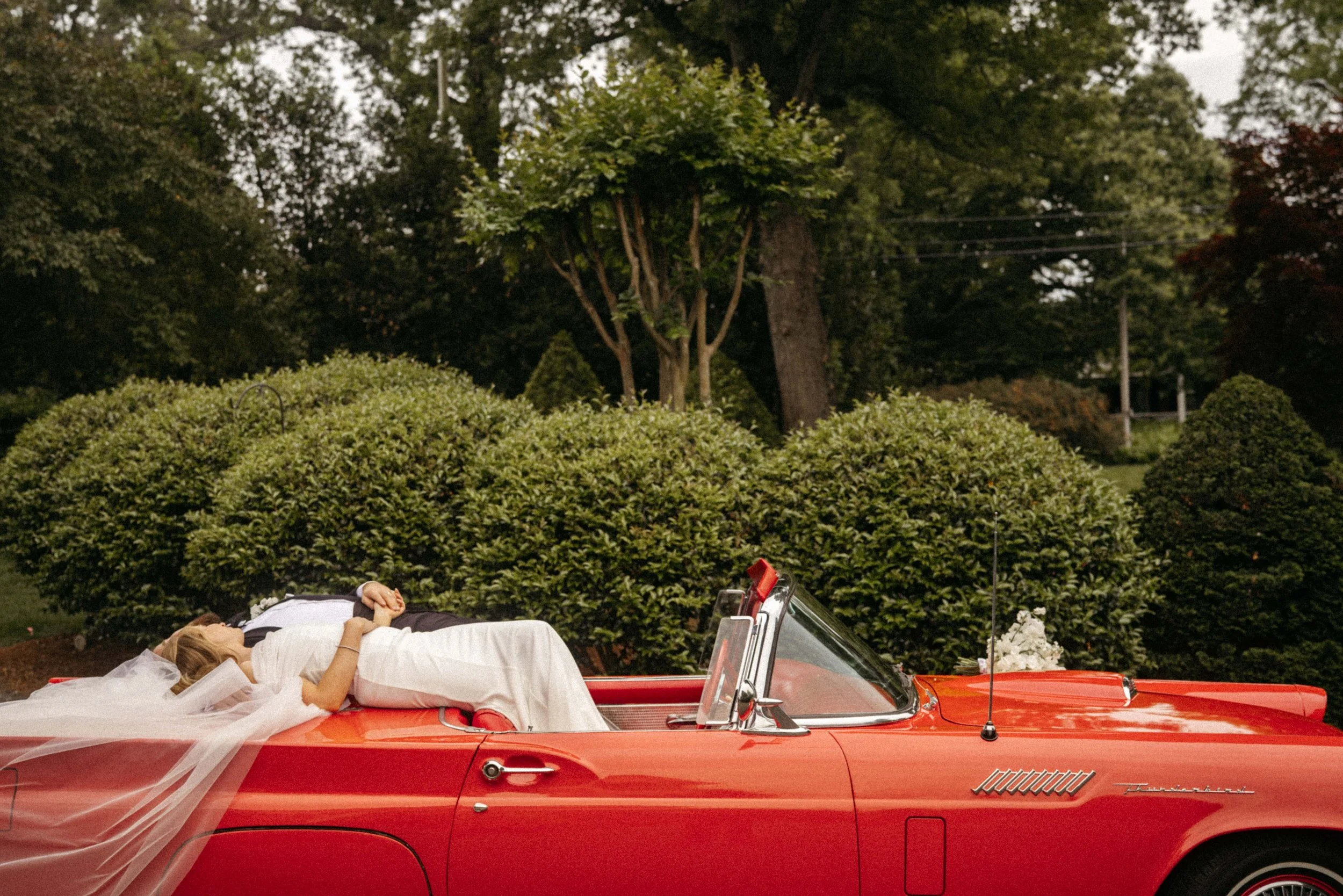 classic wedding flowers in red convertible editorial wedding detail