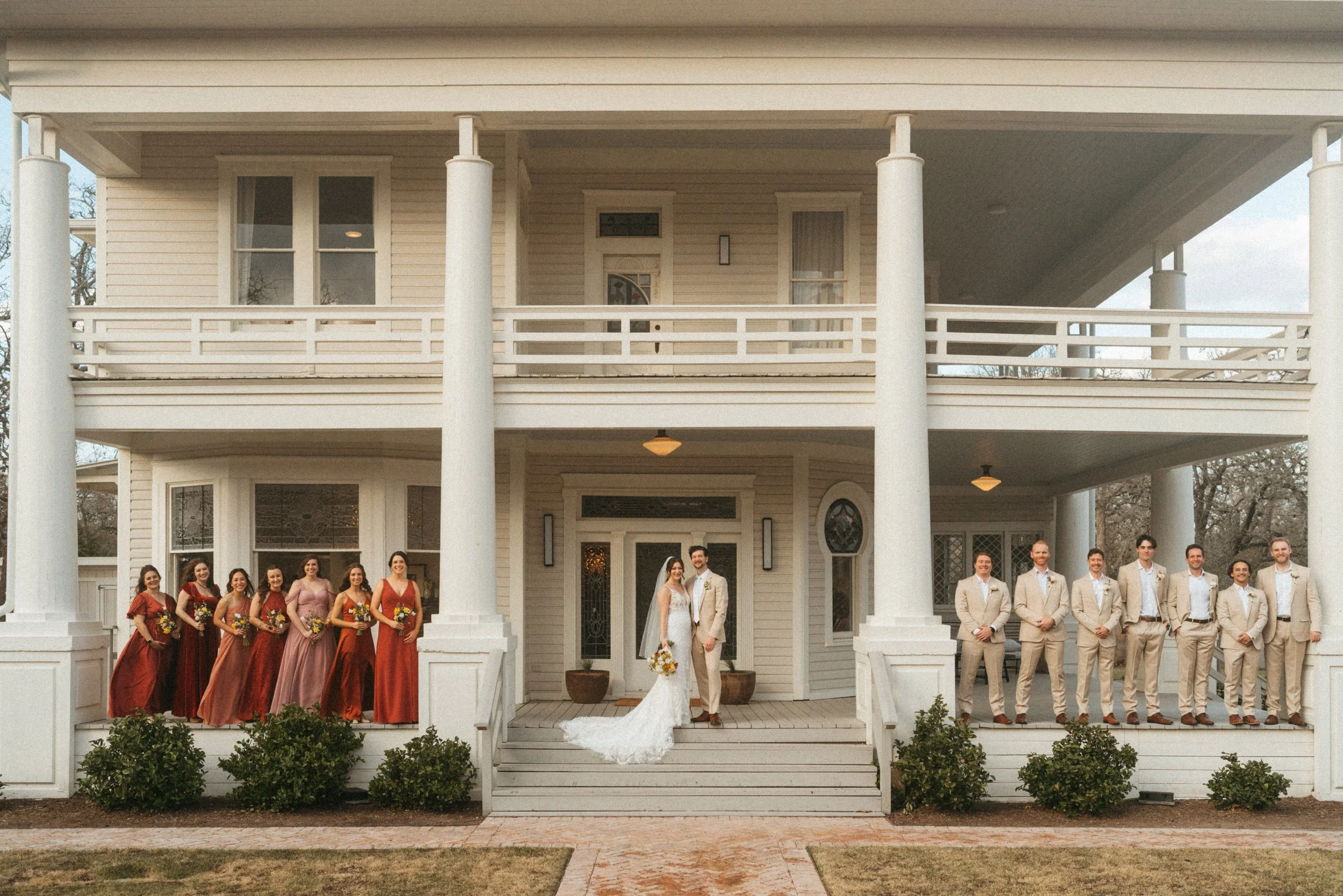 Vogue style wedding party group photo on The Grand Lady mansion porch
