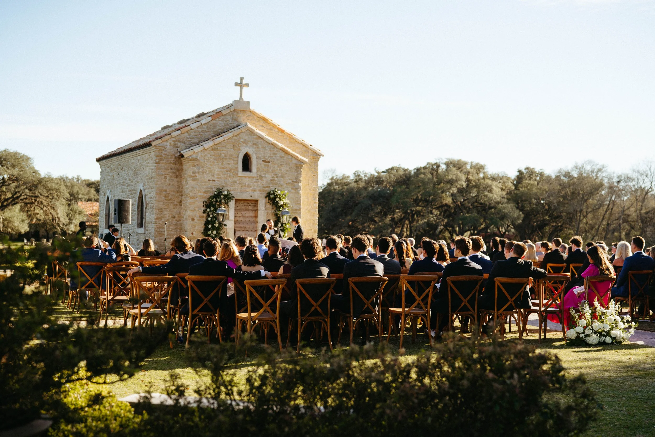 Guests seated outside the 17th-century French chapel at Houston Oaks.