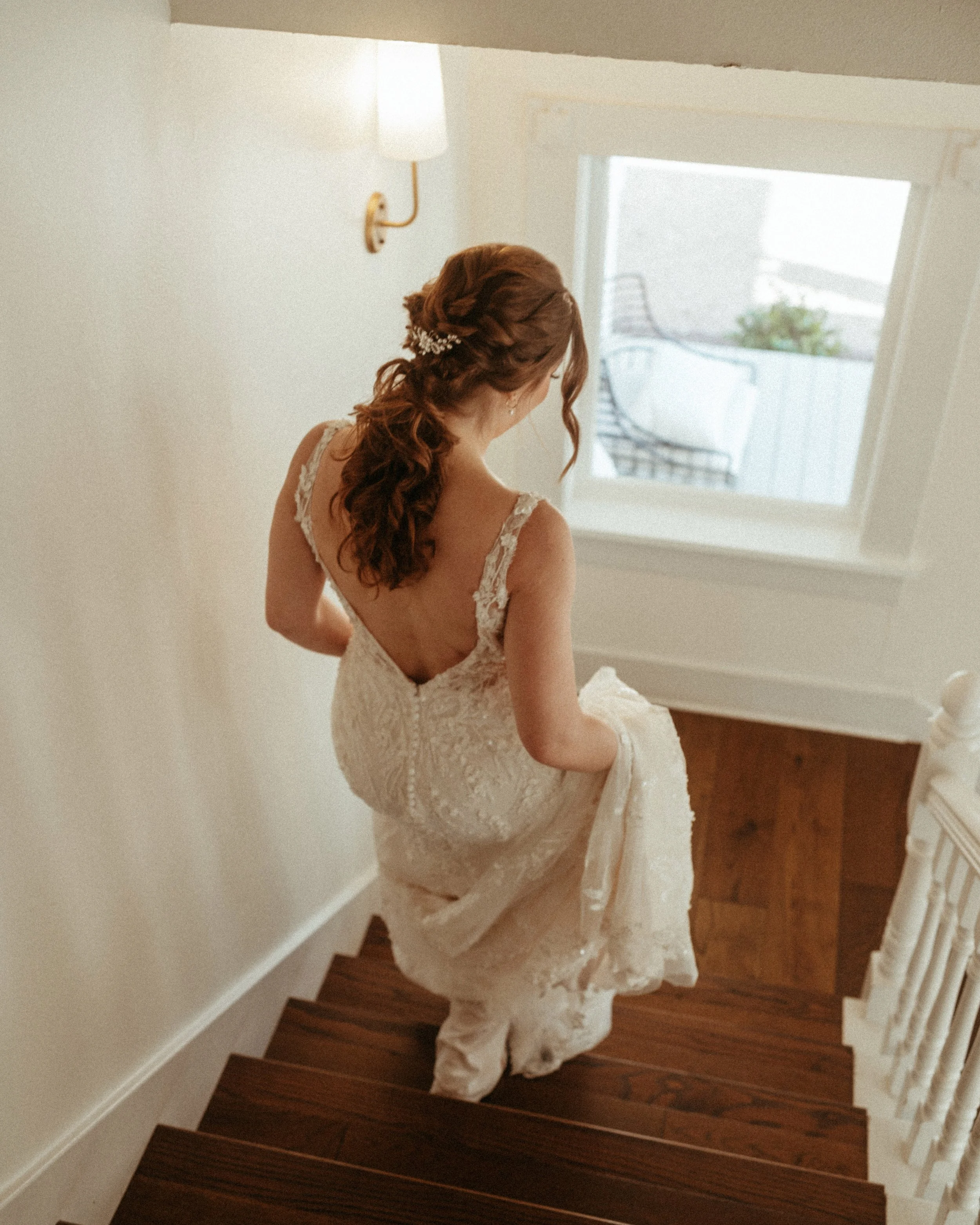 Bride walking hand down grand mansion stairway at The Grand Lady Manor TX
