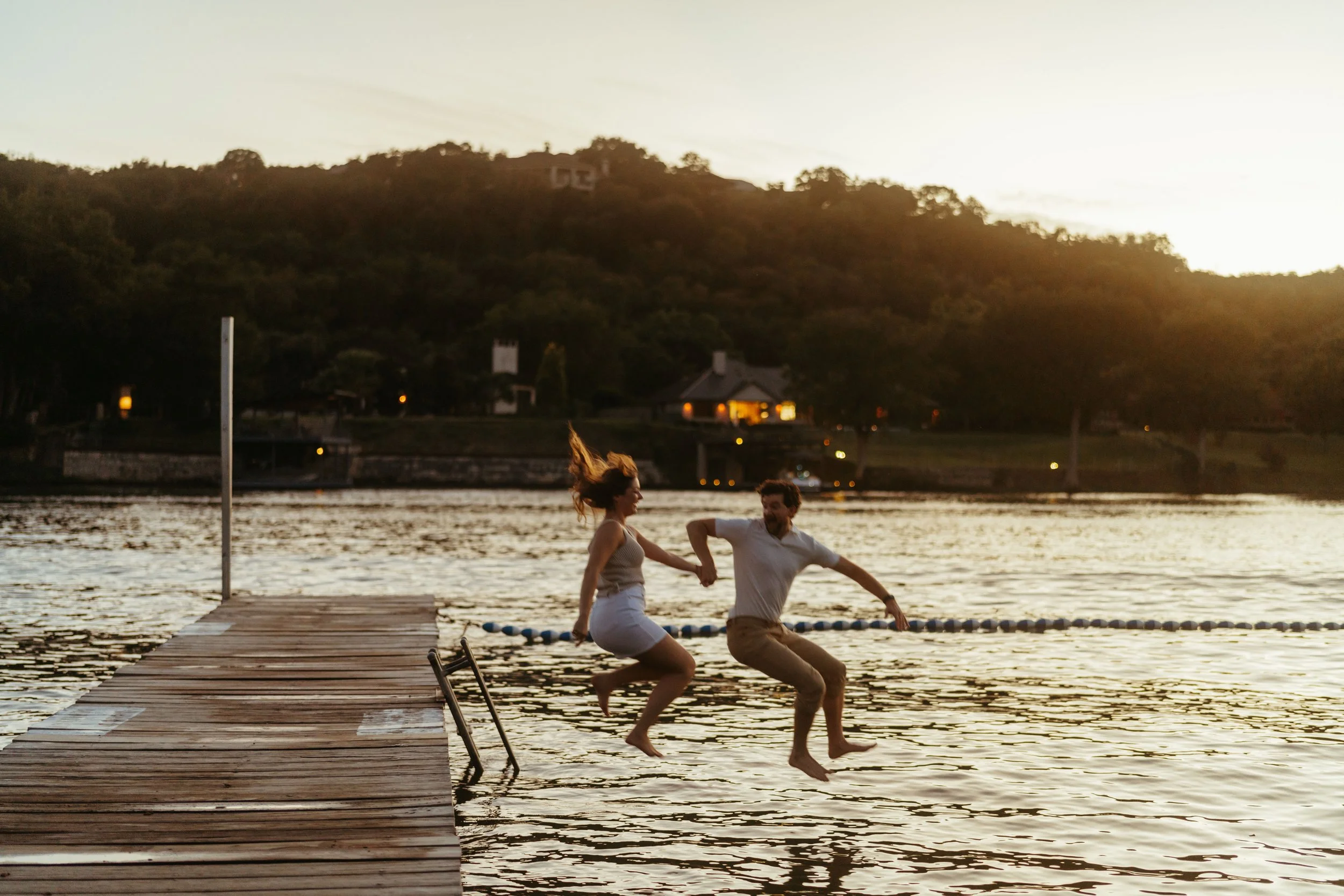Documentary style proposal photos at Emma Long Park with couple splashing in lake