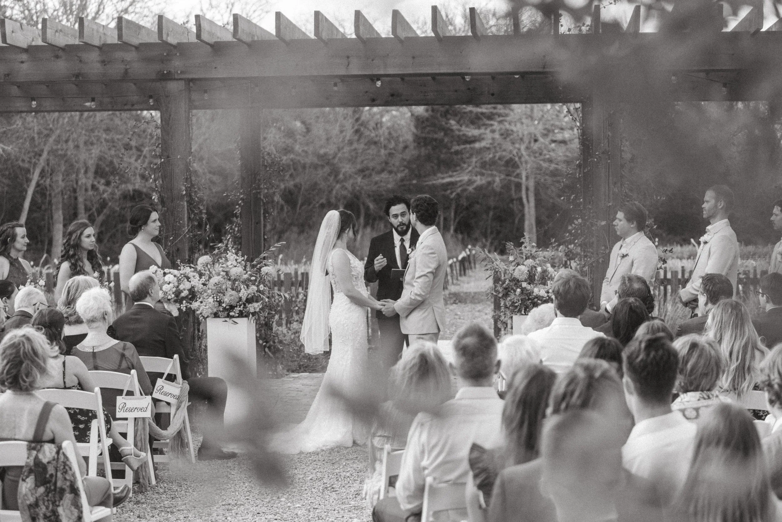 Outdoor wedding ceremony at The Grand Lady with in-house florals and oak trees in the background
