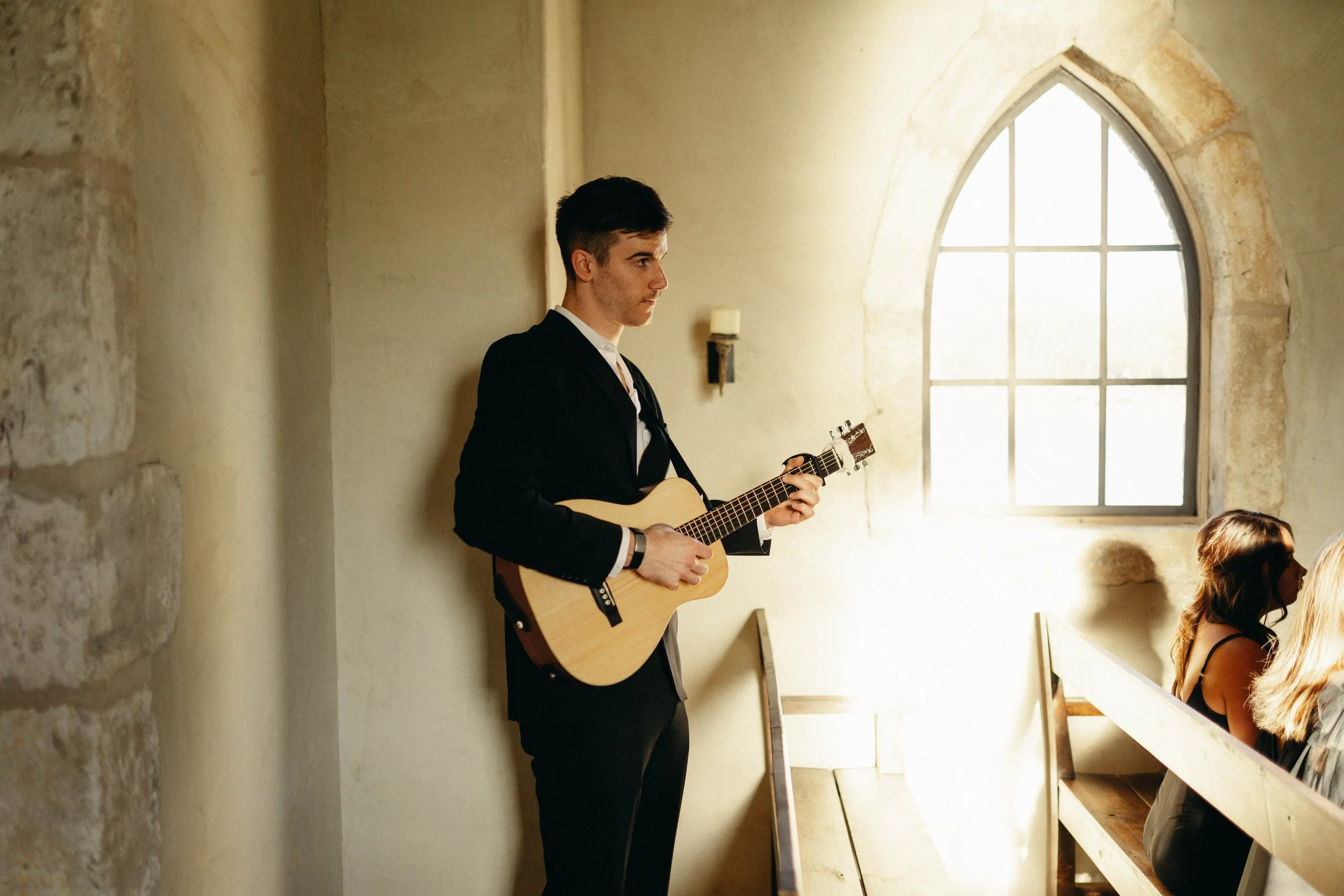 Private worship musician playing softly during communion between bride, groom, and wedding party at the french chapel at houston oaks.
