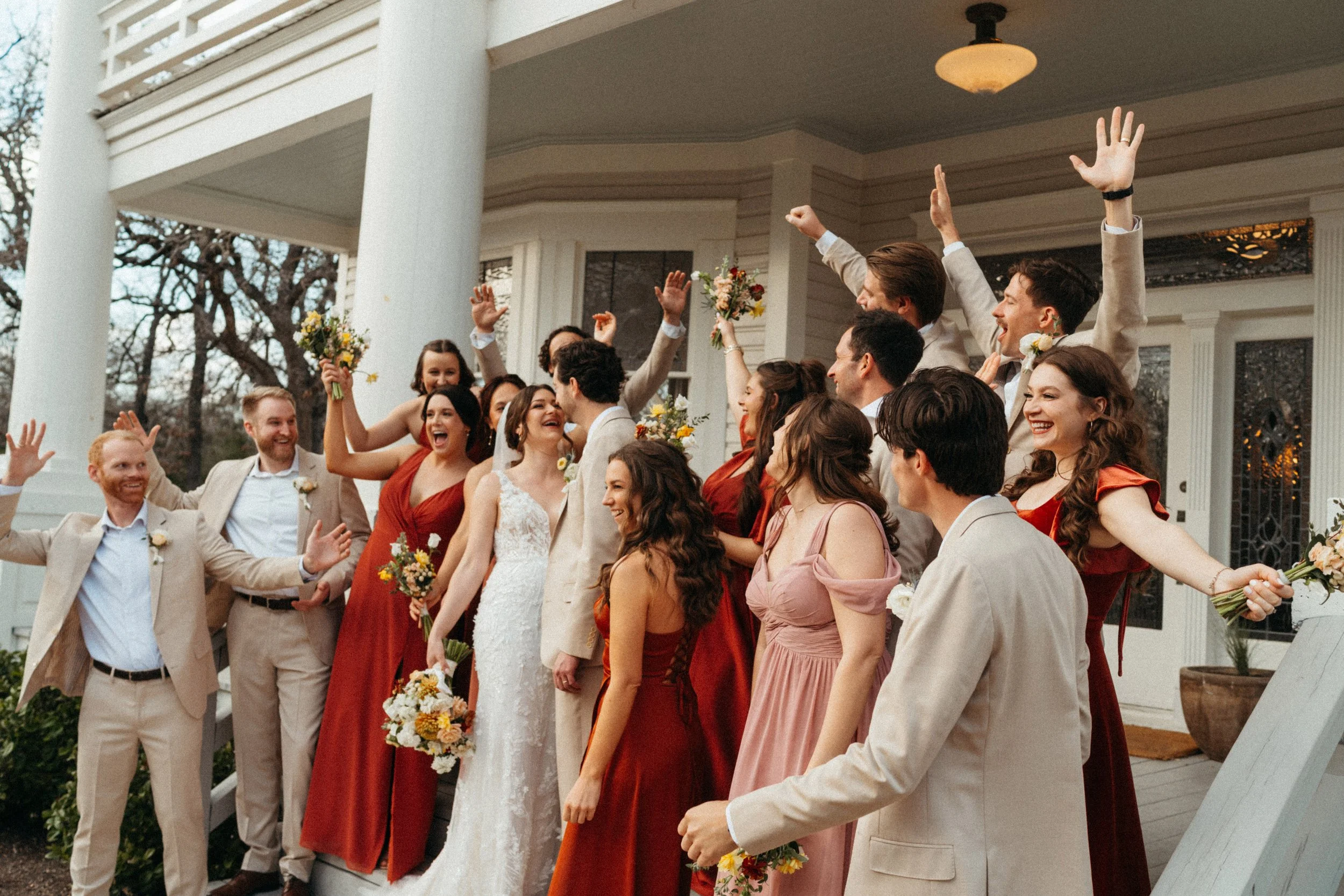 candid fun wedding party group photo on the porch of The Grand Lady mansion